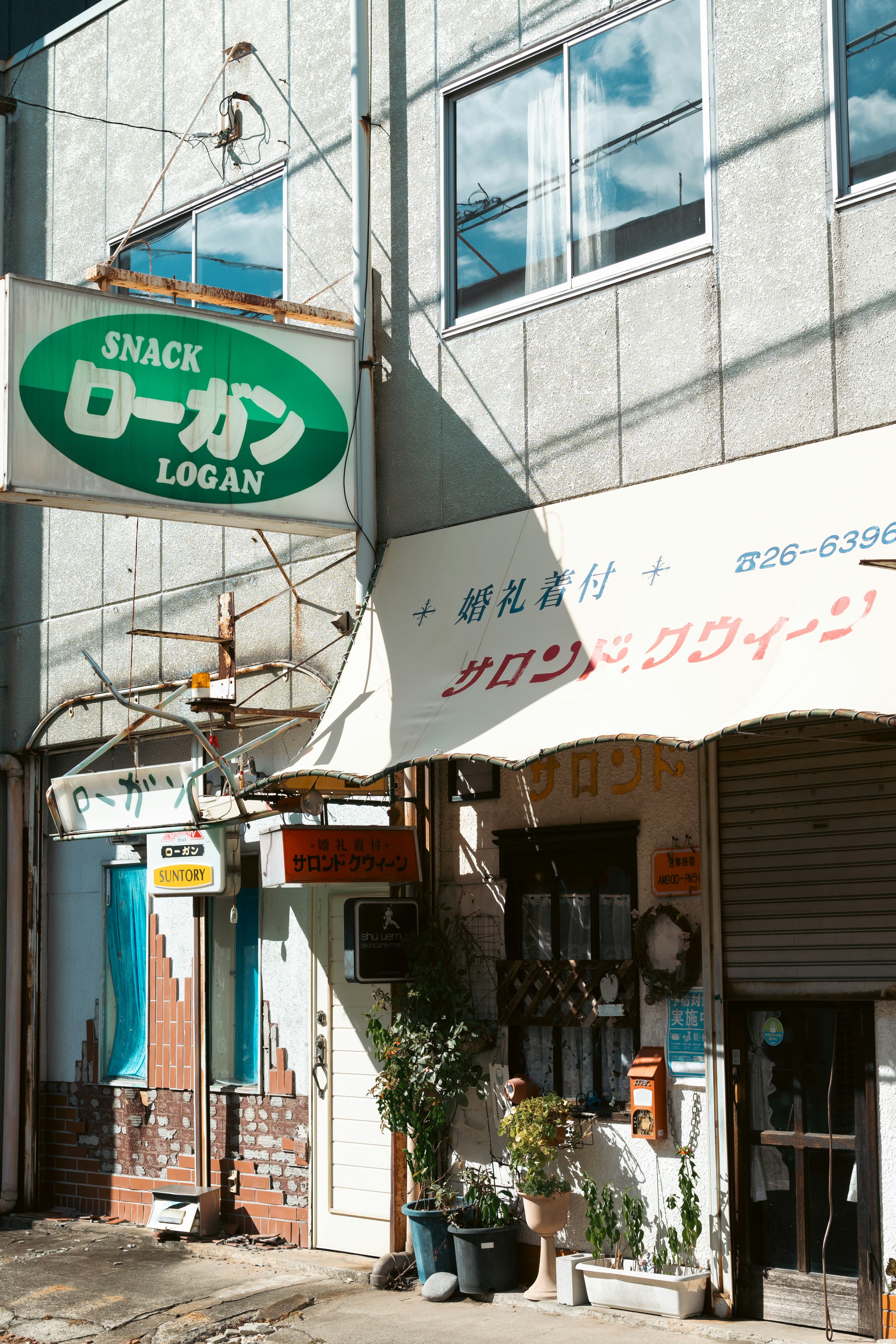 Extérieur d'un snack bar rétro appelé Logan avec un panneau vert et une architecture japonaise traditionnelle