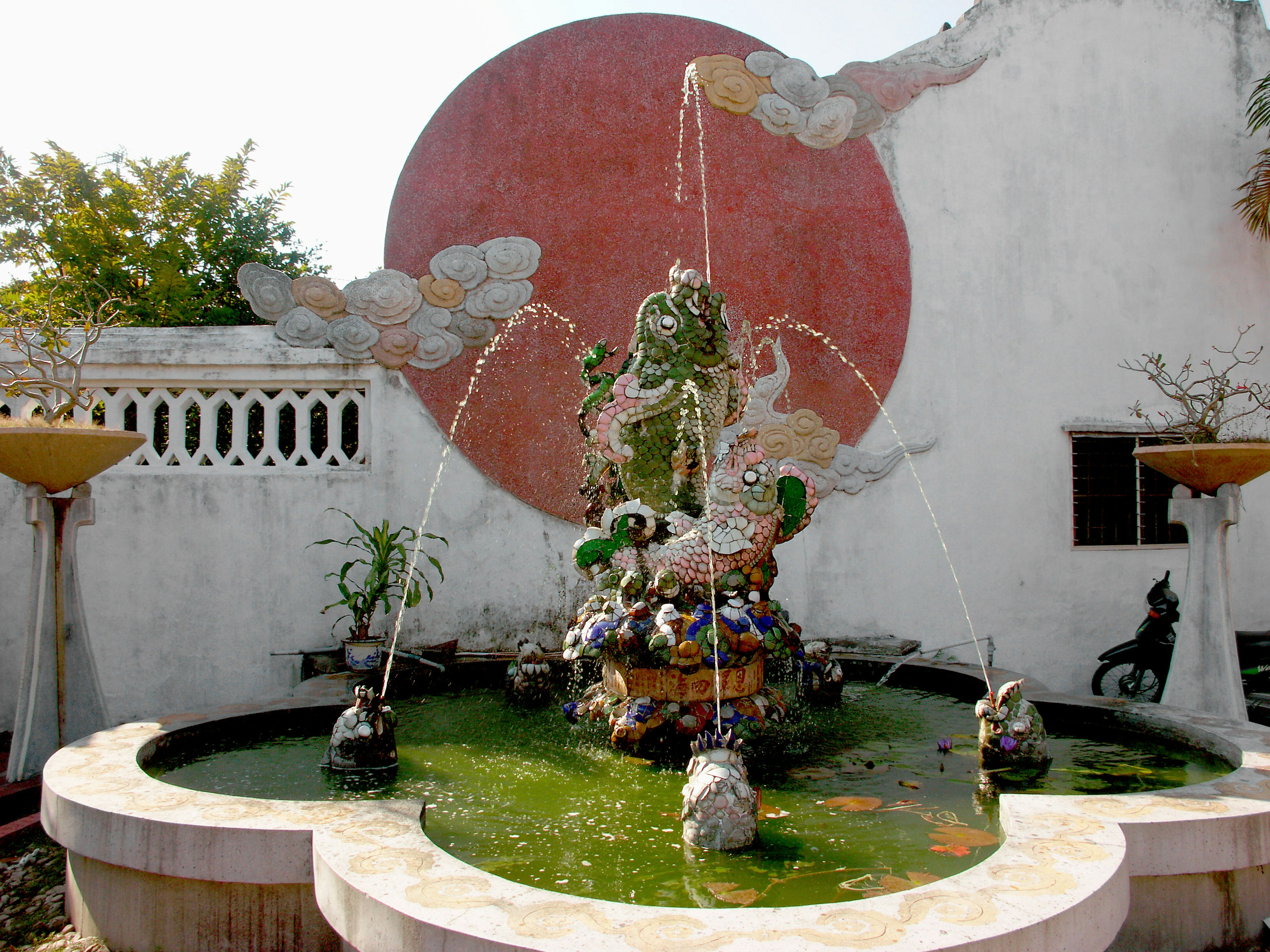 Garden with a fountain and decorative wall featuring a large red circle