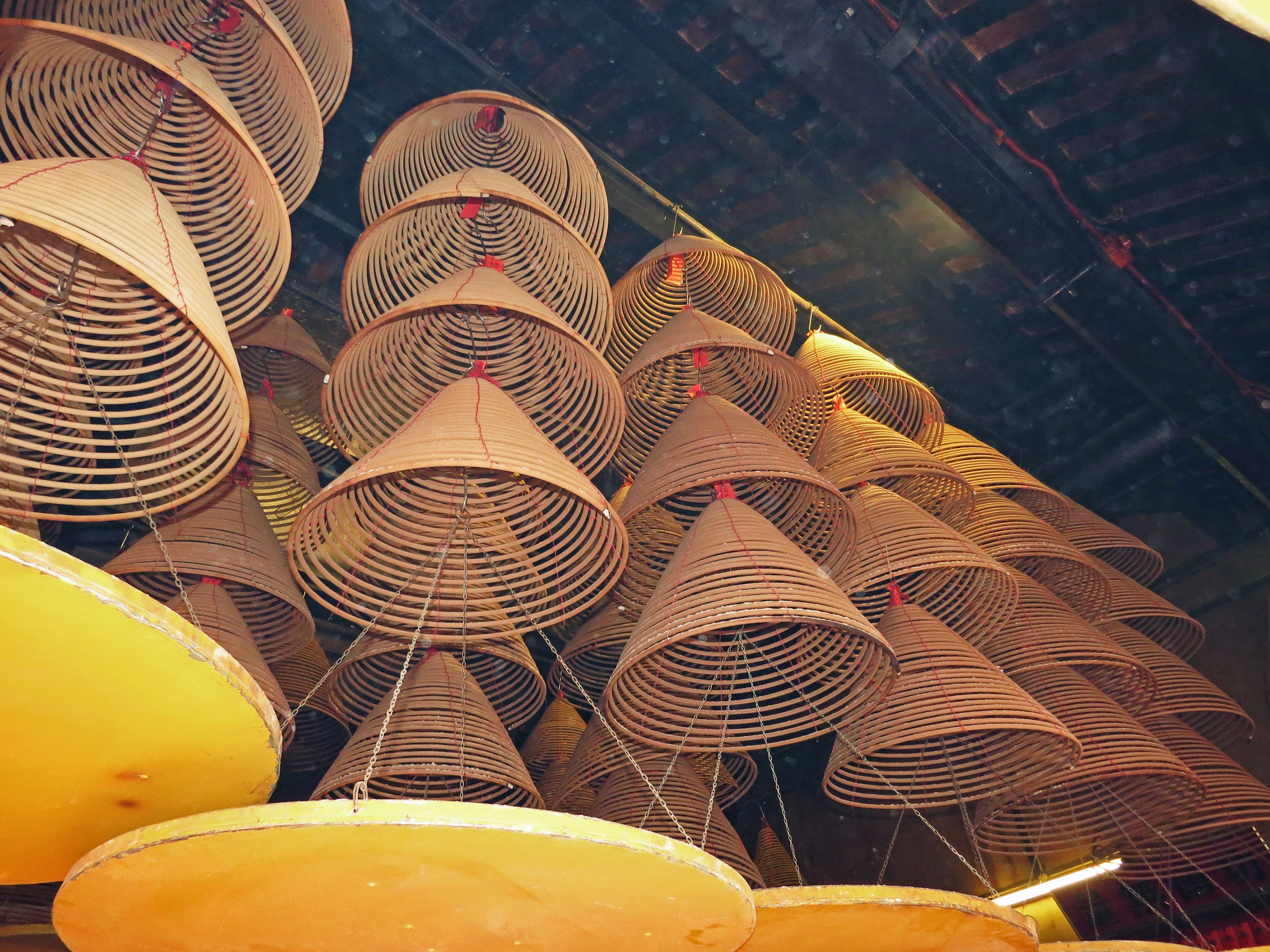 Indoor scene featuring hanging cone-shaped baskets and circular plates