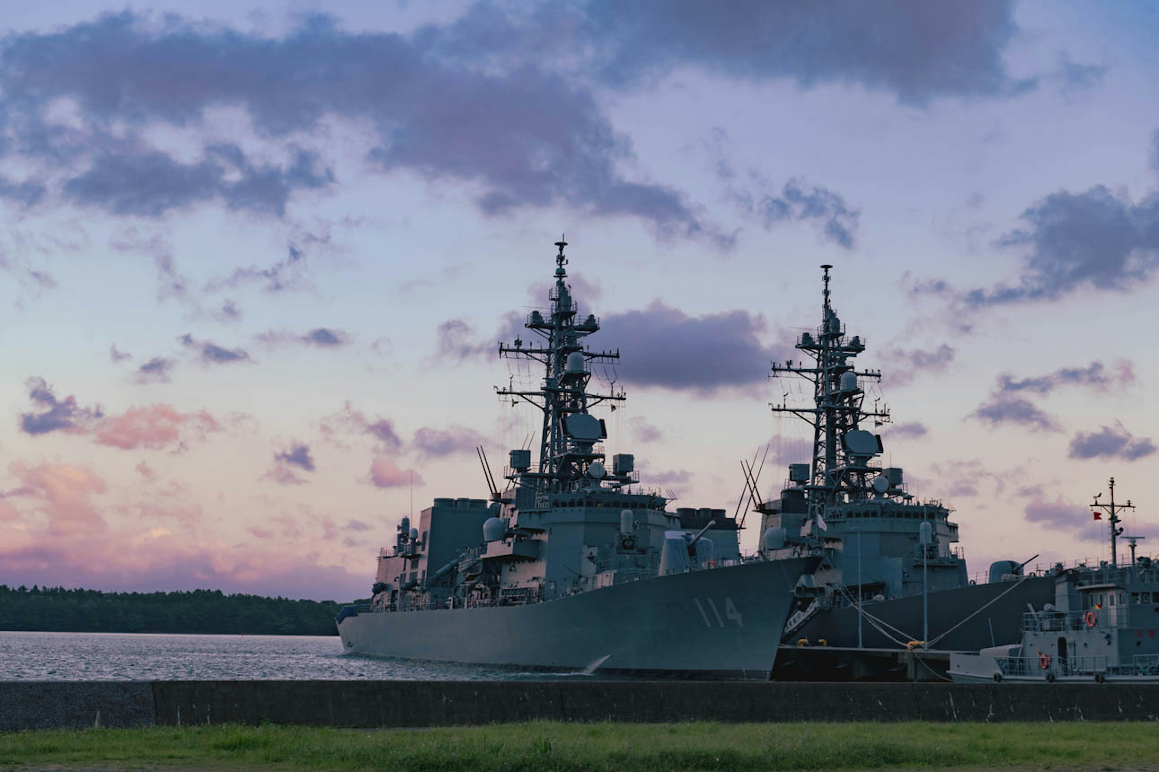 港に停泊する軍艦のシルエットと美しい夕焼けの空