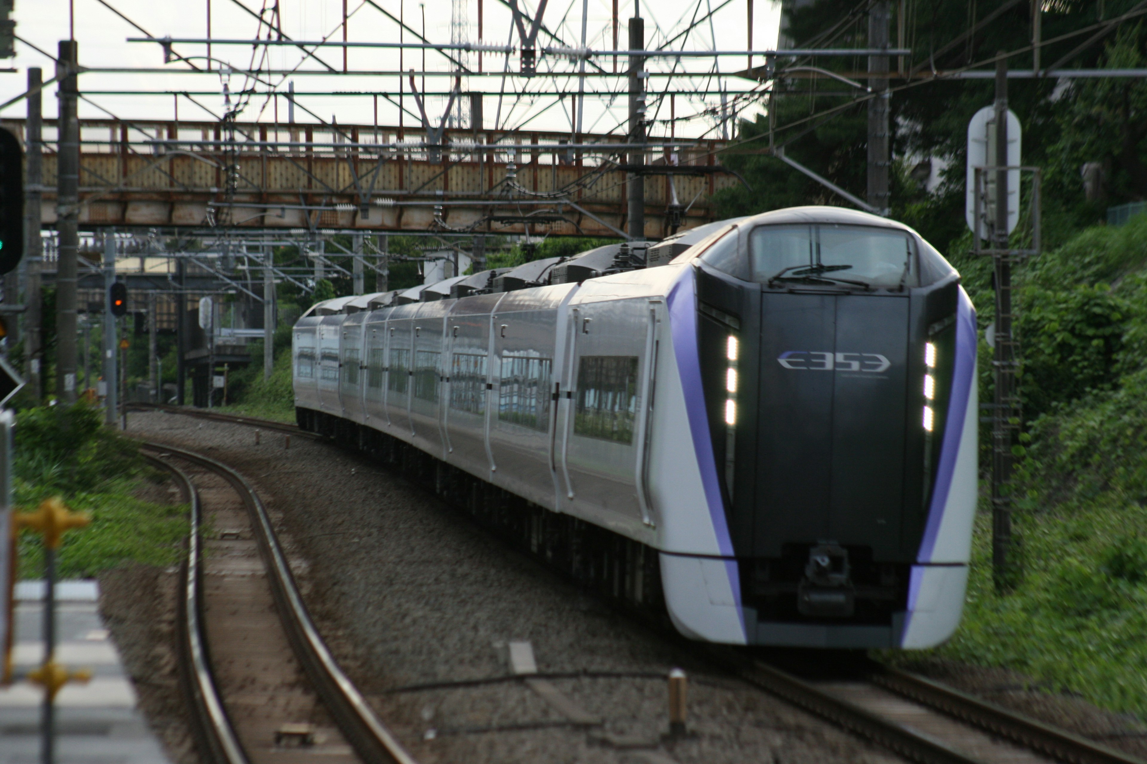 一列現代火車在軌道上行駛，經過一座橋