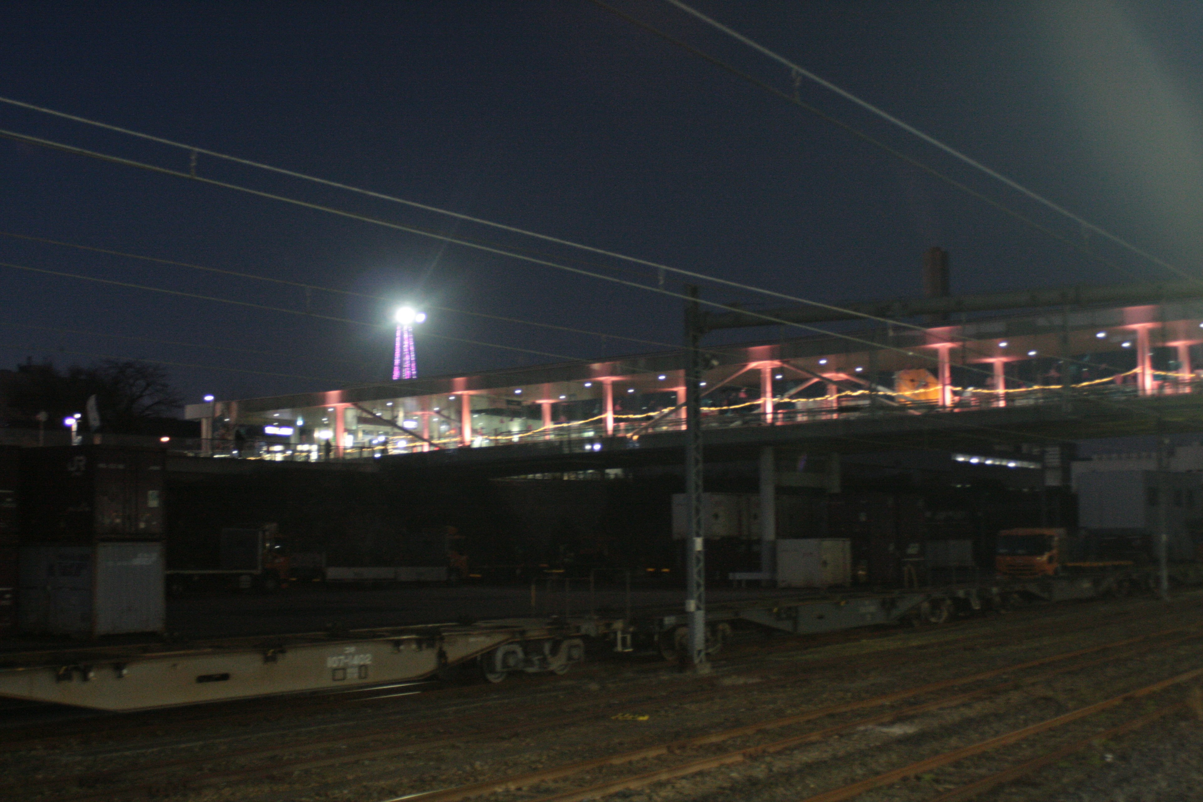 夜の鉄道橋と周囲の照明が映る風景