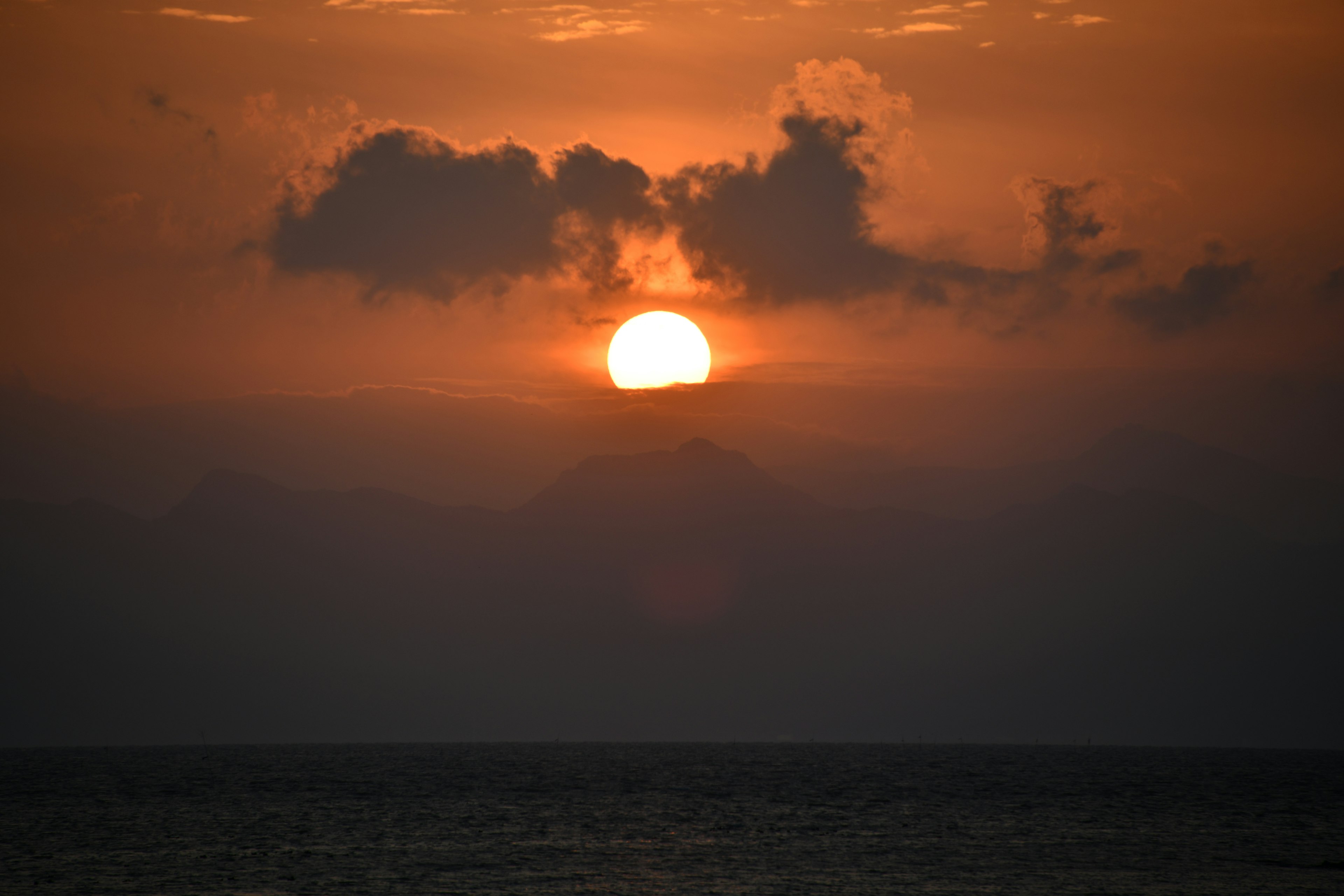 夕日が雲の間から見える海の風景