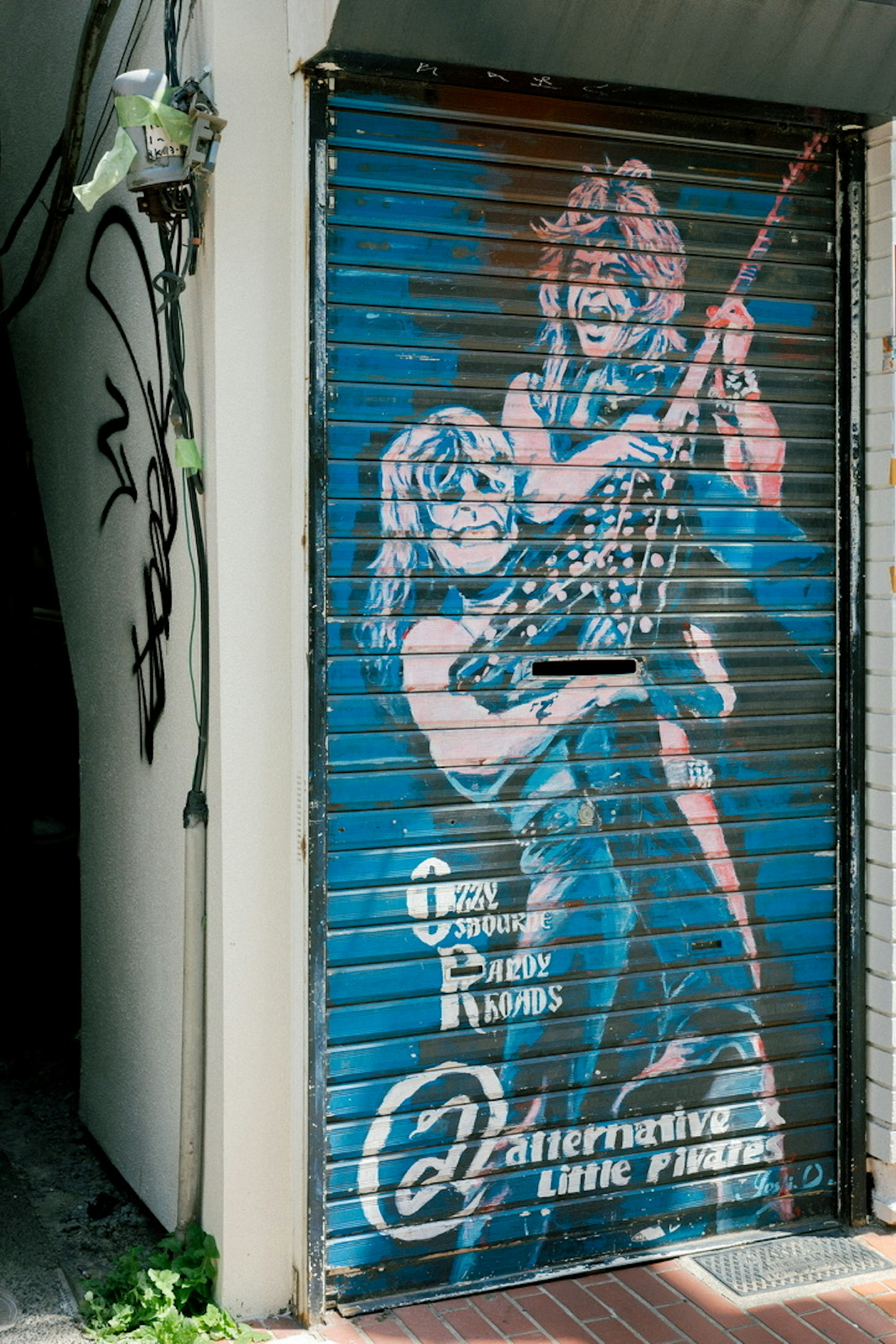 Graffiti di due musicisti rock su una serranda blu