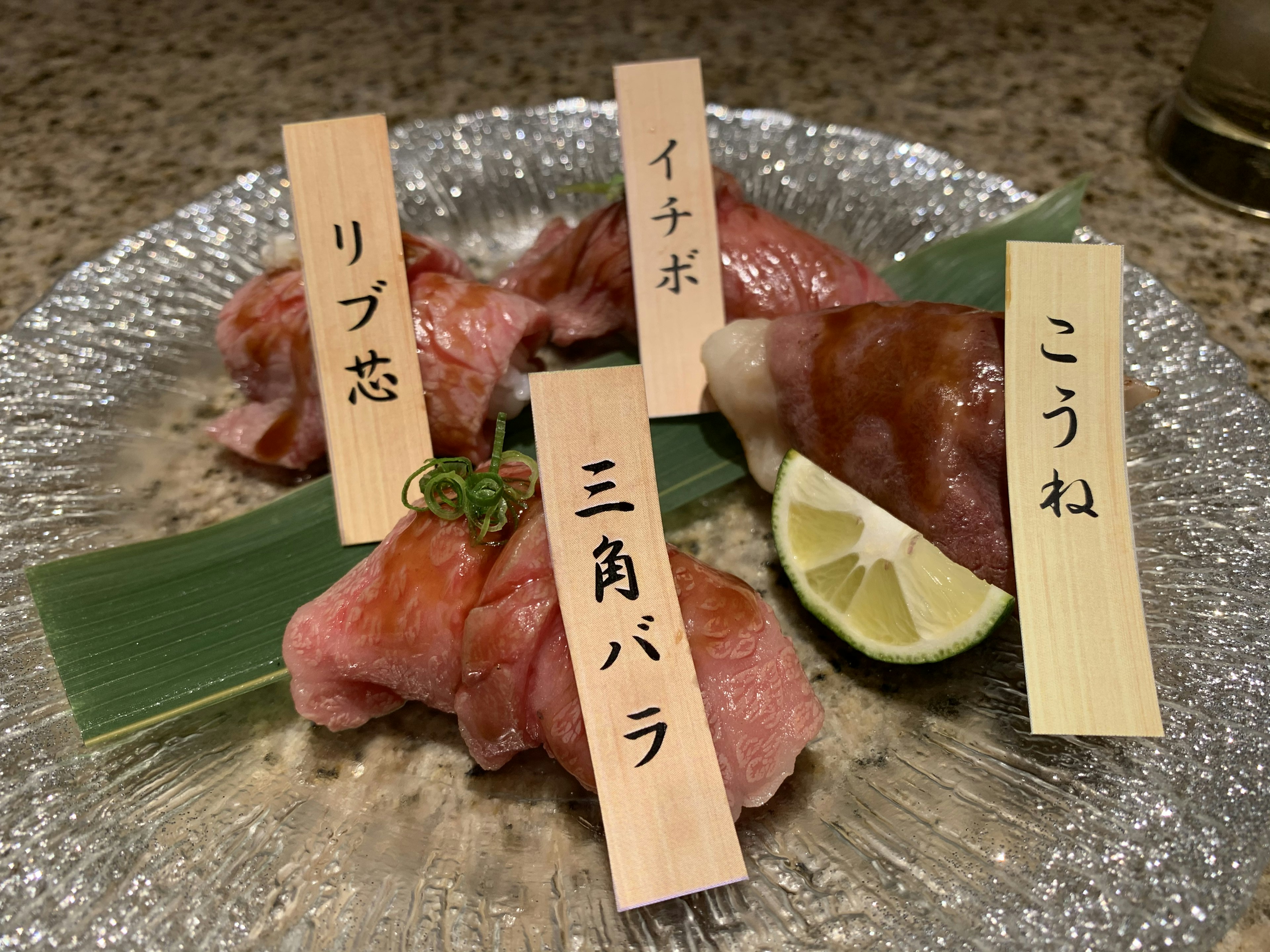 Un plato de sushi variado con etiquetas que indican cada tipo de sushi