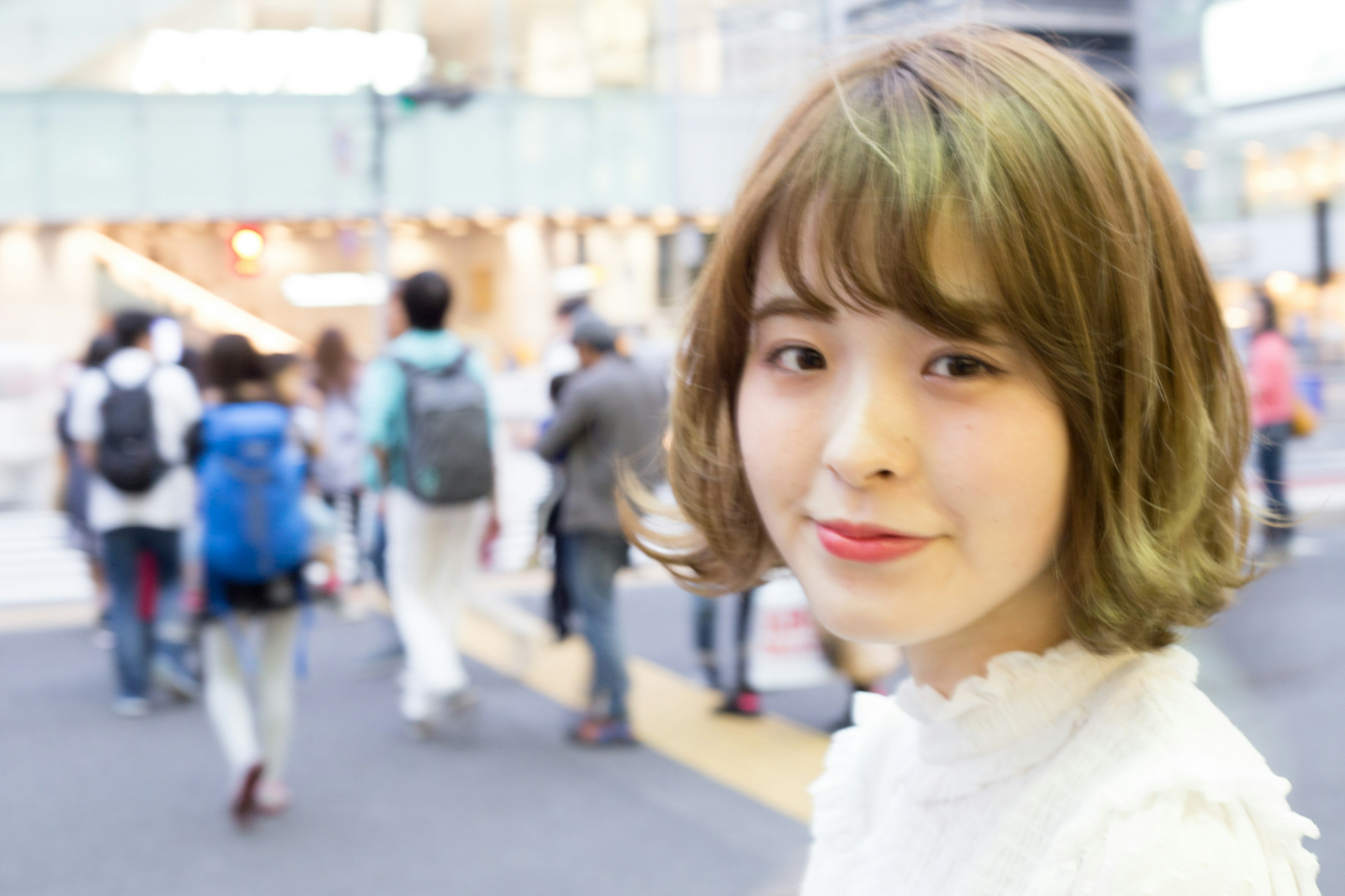 Portrait of a smiling woman in the city with people walking in the background