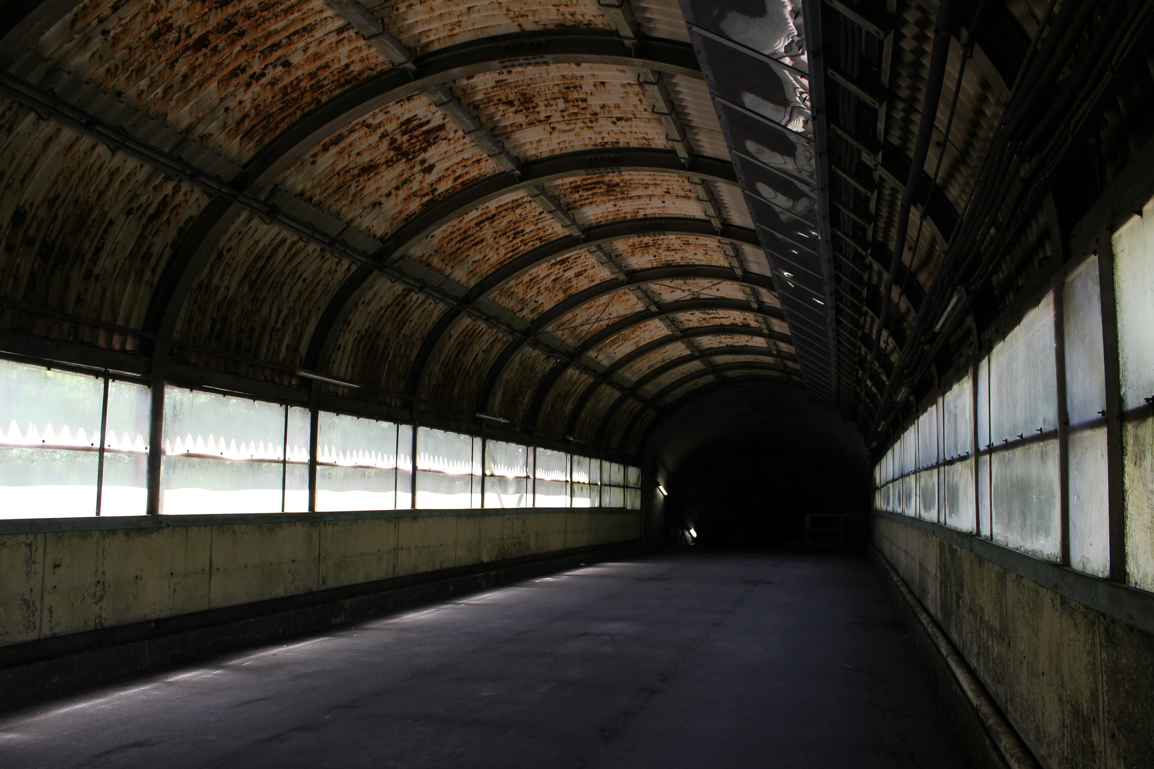 Interior of a long tunnel with weathered brick walls natural light streaming through windows