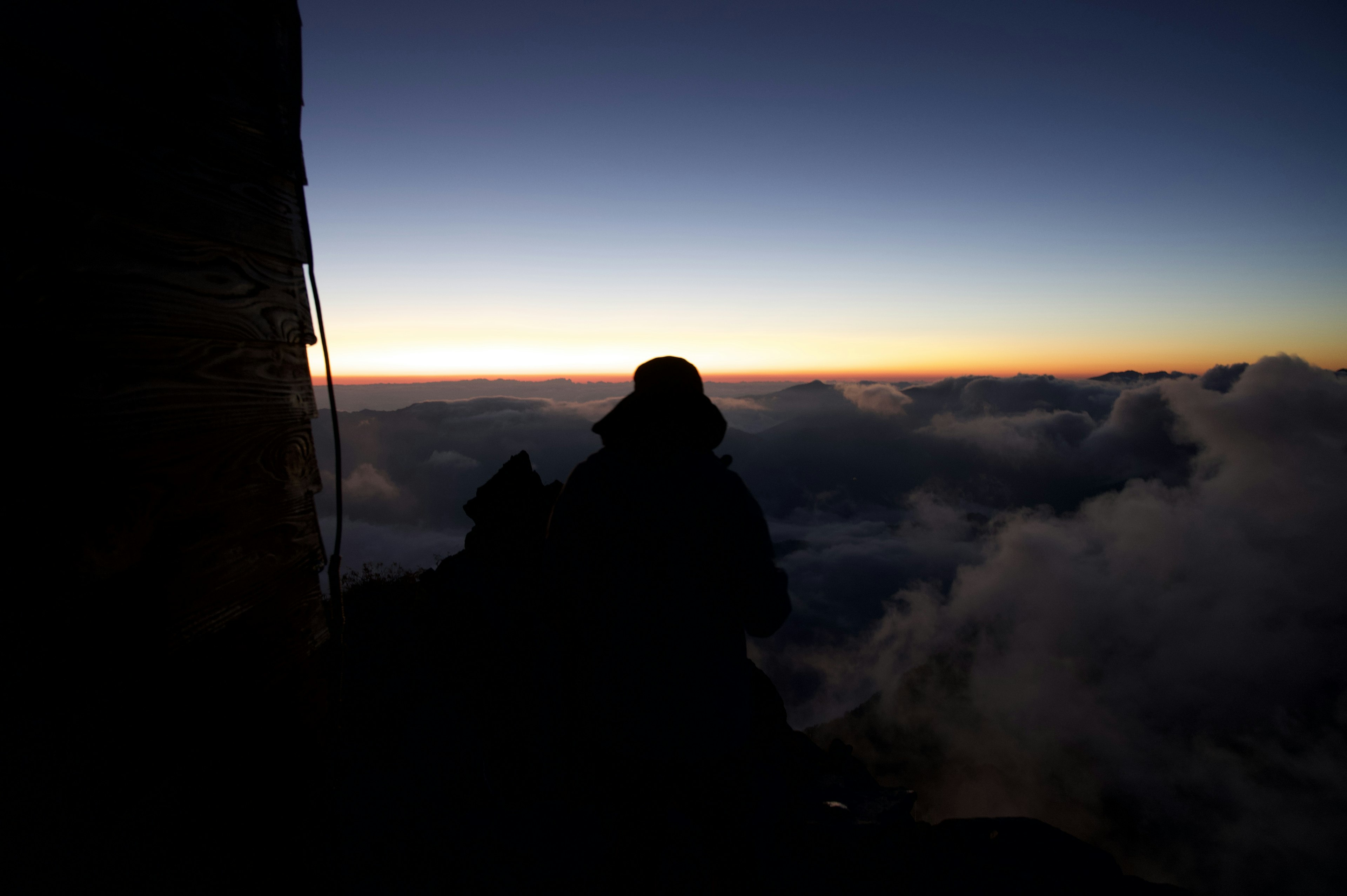 Silhouette einer Person auf dem Berggipfel mit Sonnenaufgang