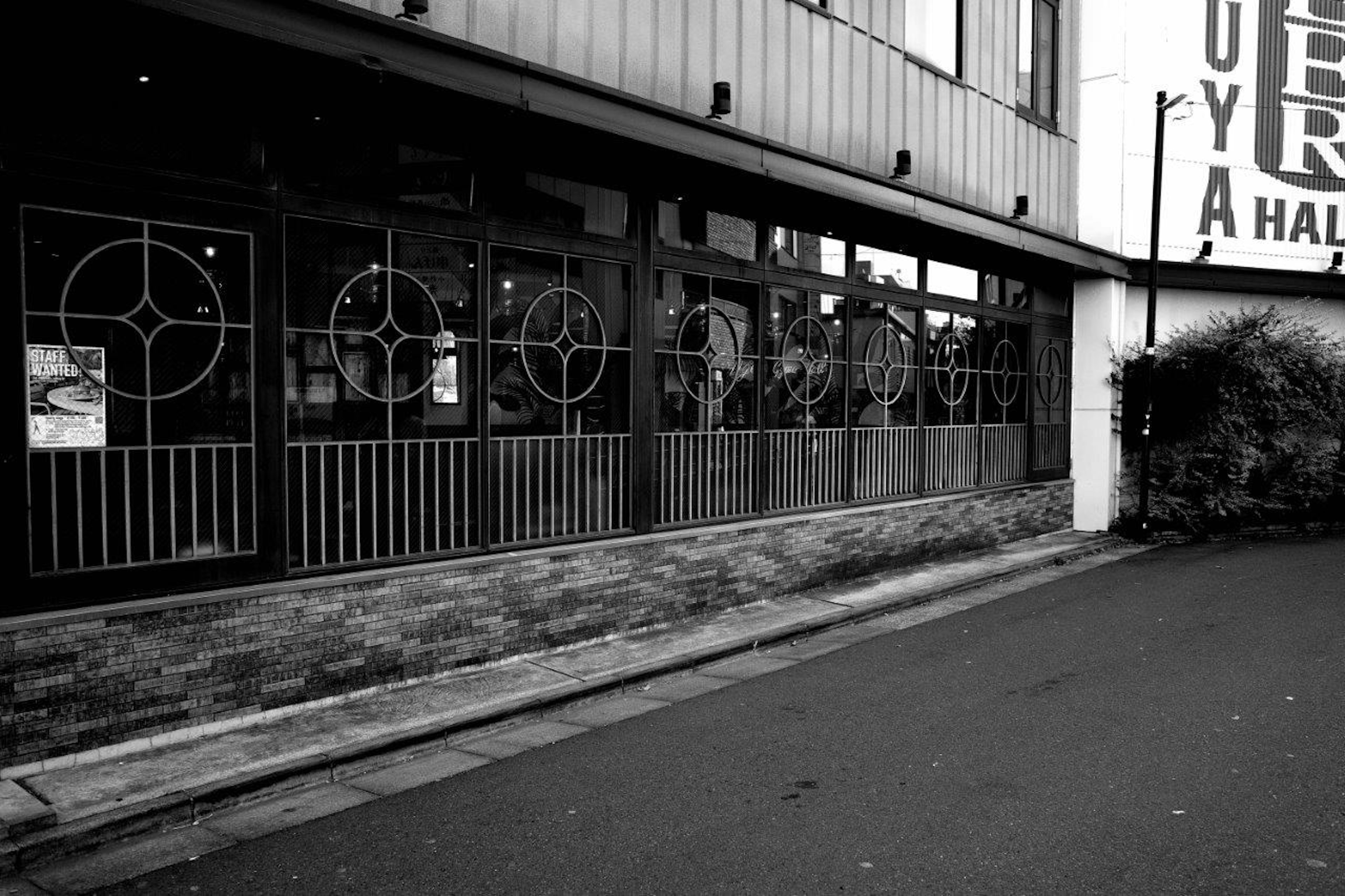 Exterior de un edificio en blanco y negro con ventanas decorativas y base de piedra