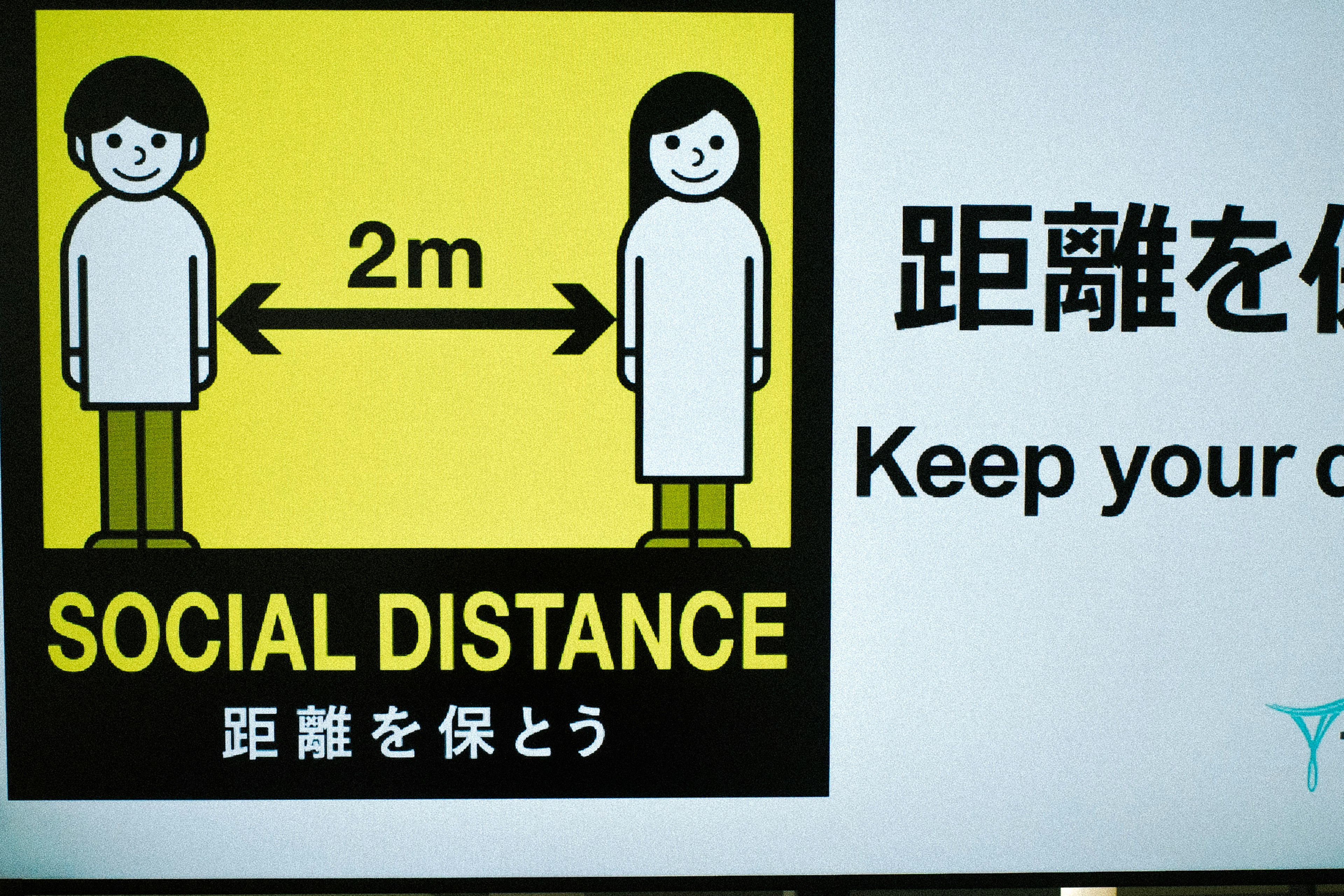 Sign promoting social distance featuring two figures maintaining a 2 meter distance