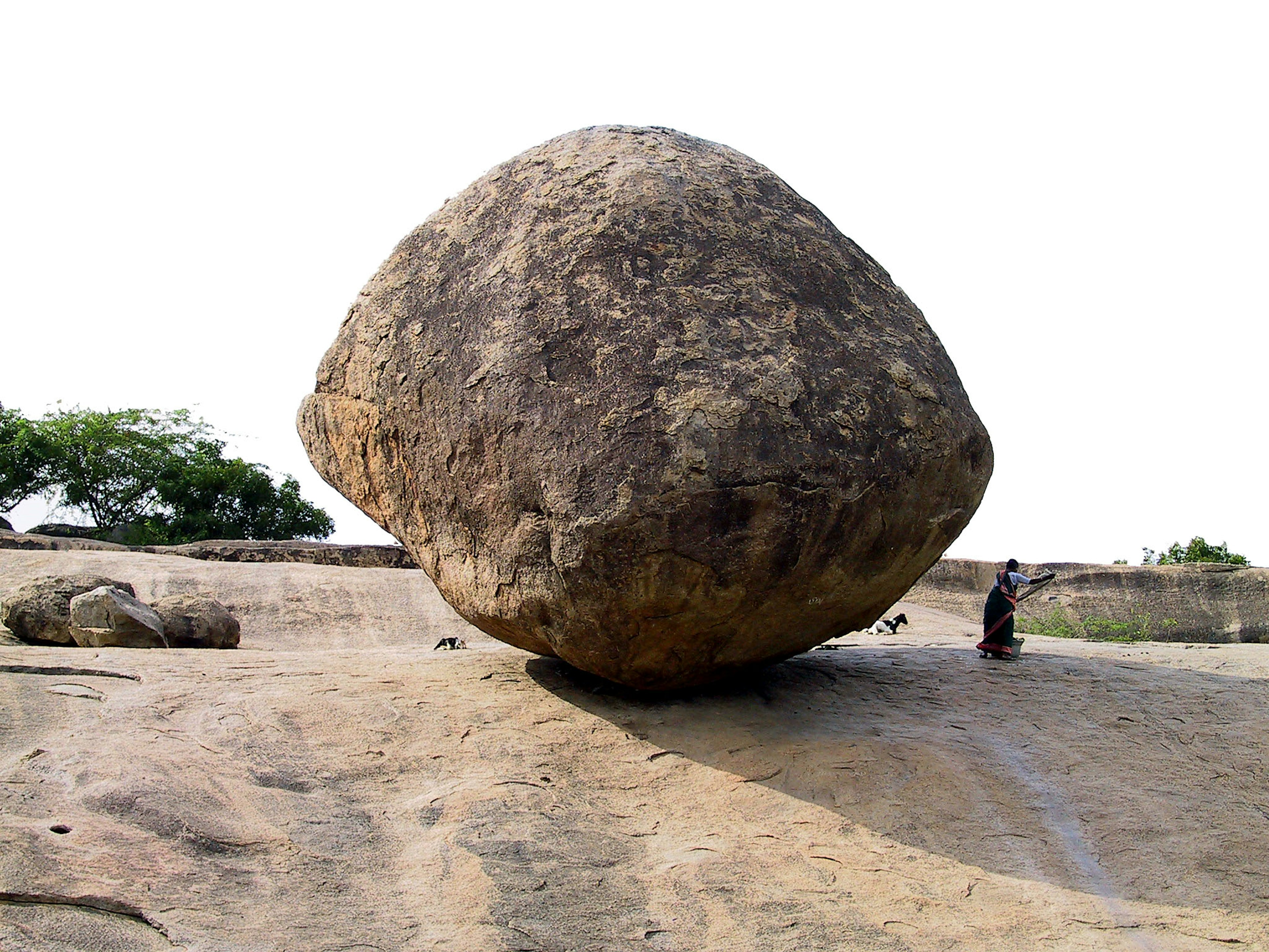 Ein großer, kugelförmiger Felsen, der auf einer geneigten Fläche balanciert