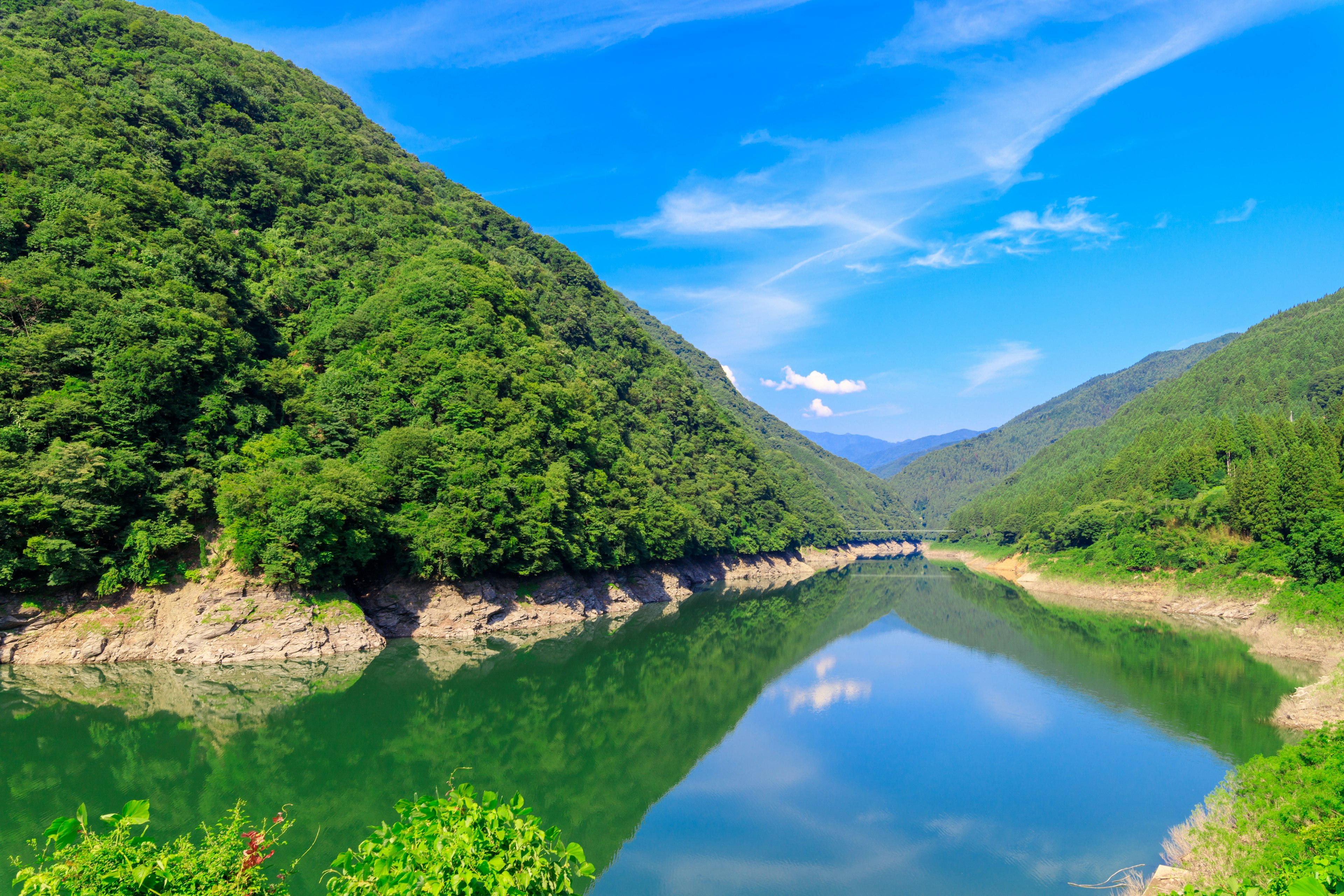 宁静的河流景观，绿色山脉和蓝天