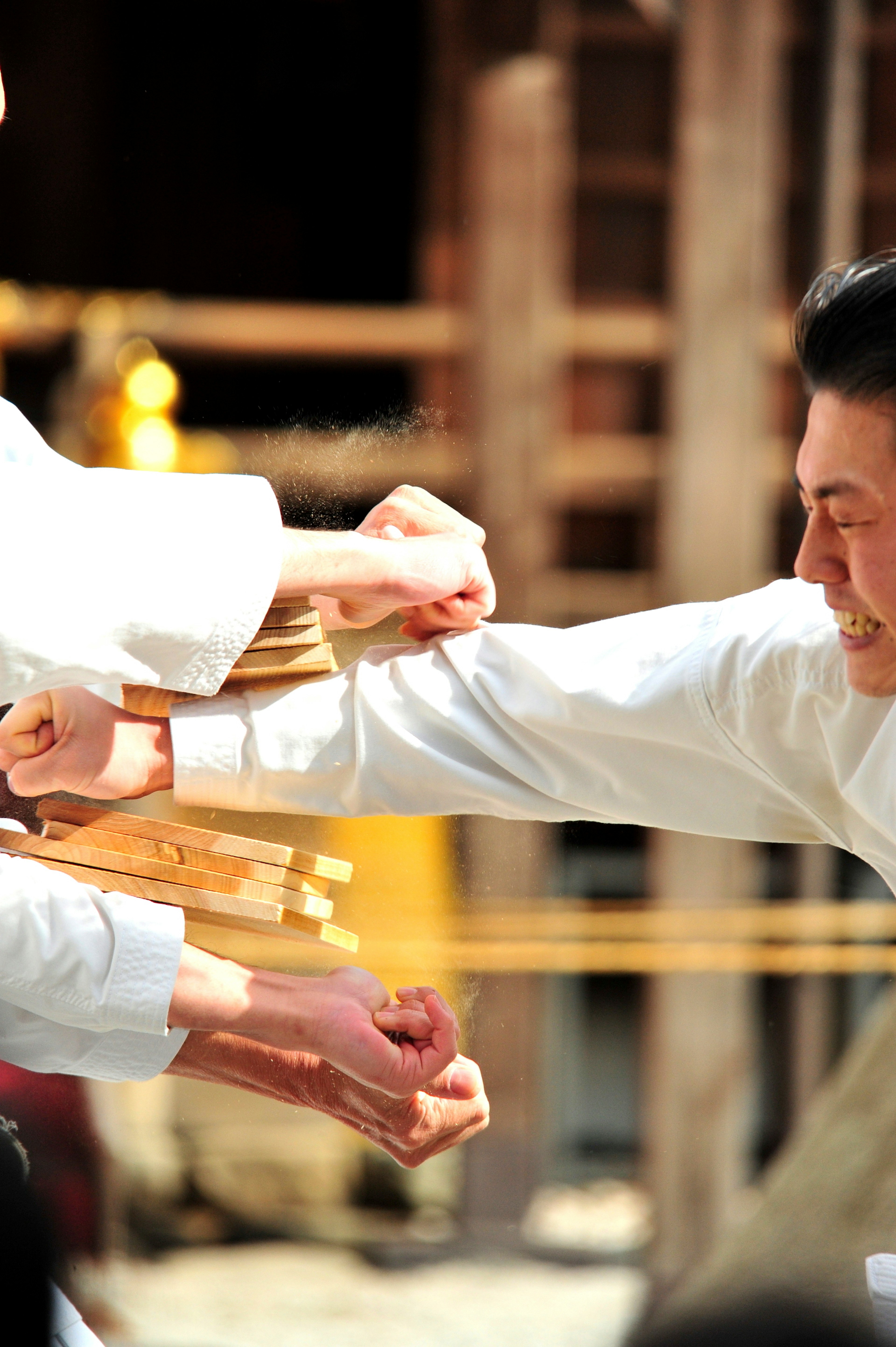 Two martial artists practicing breaking wooden boards