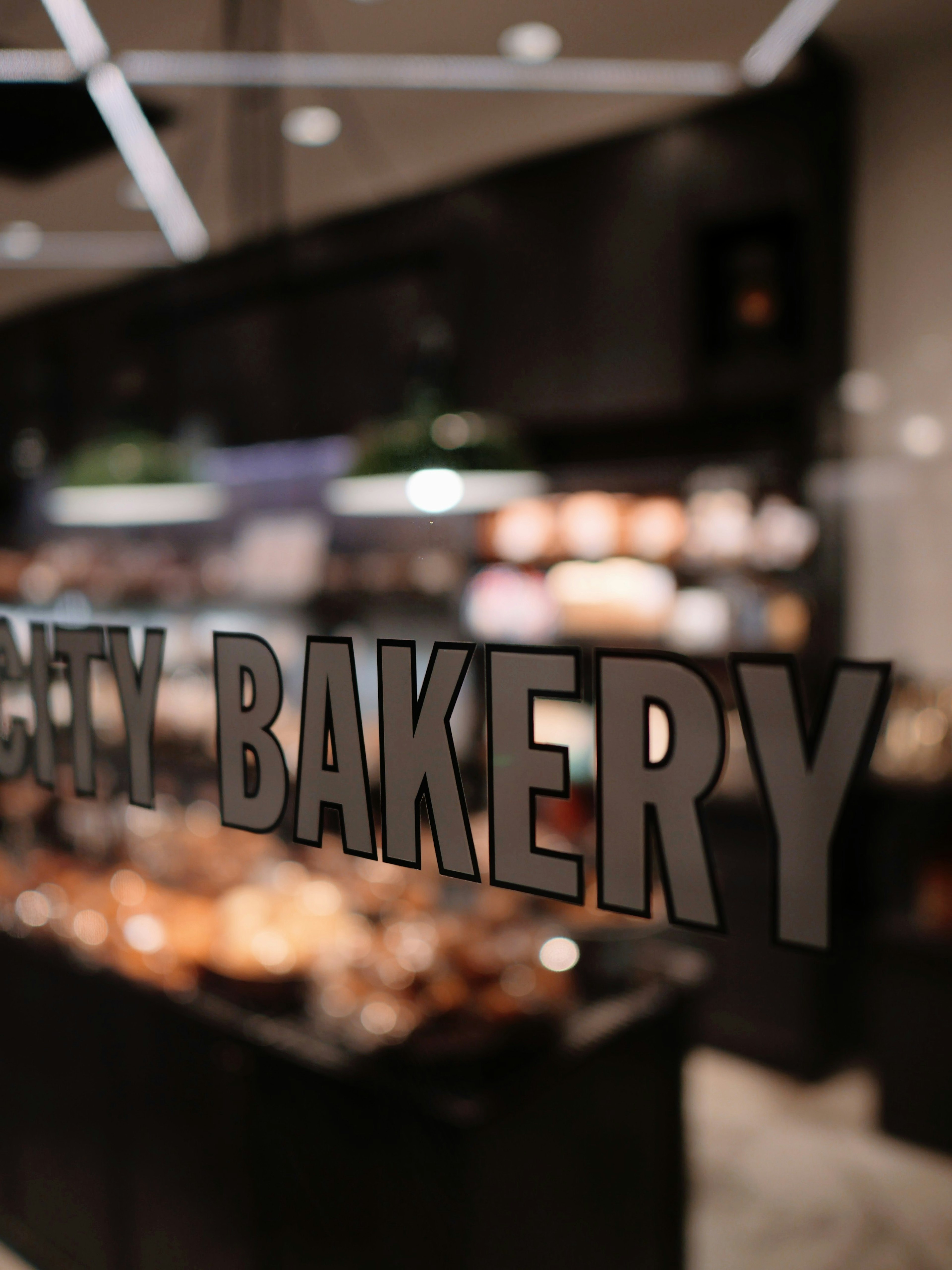 Photo of a bakery sign with a display case of baked goods