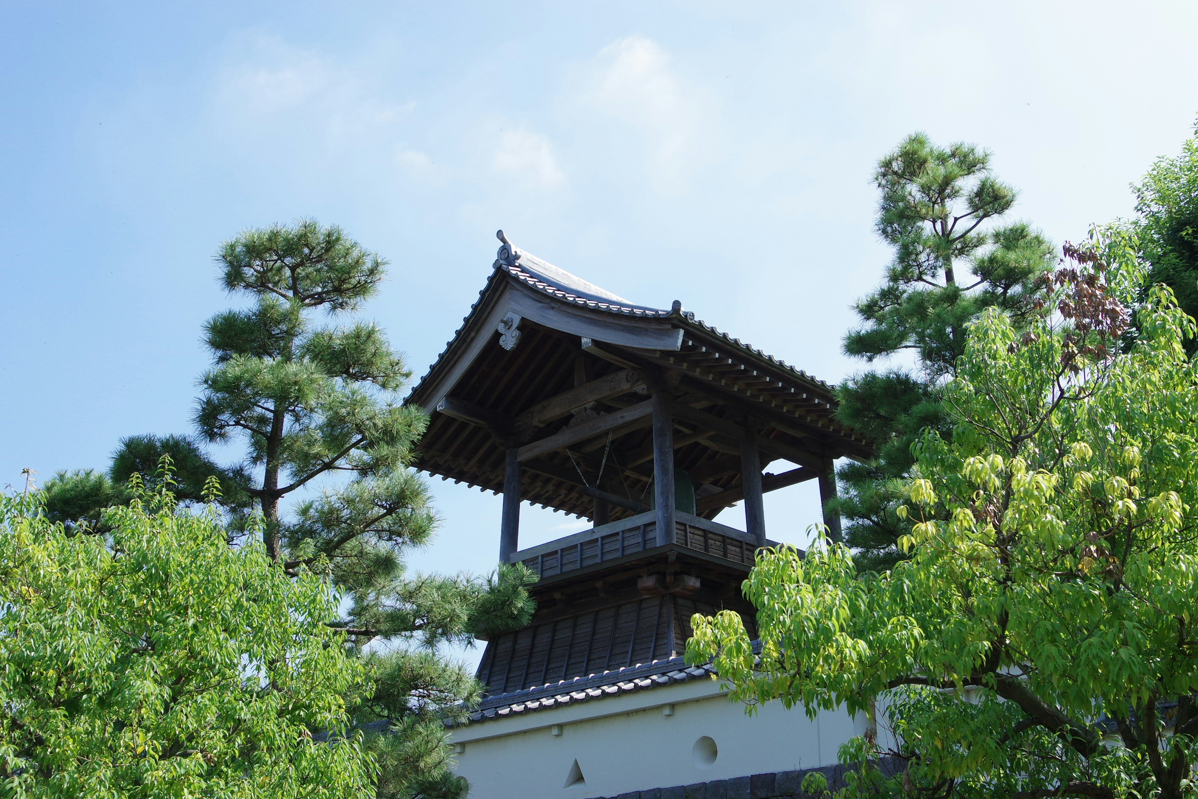 Schöner japanischer Turm unter blauem Himmel mit grünen Bäumen