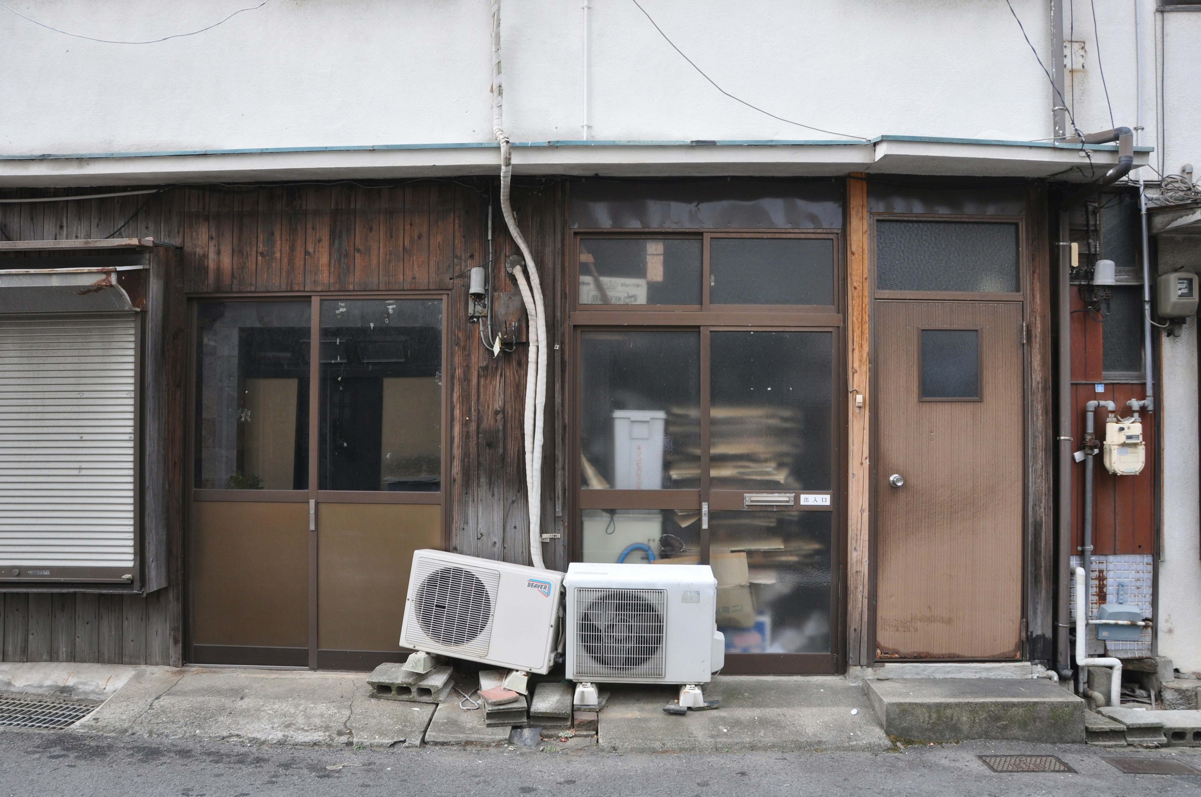 Fachada de un antiguo edificio de madera con ventanas de vidrio en una calle