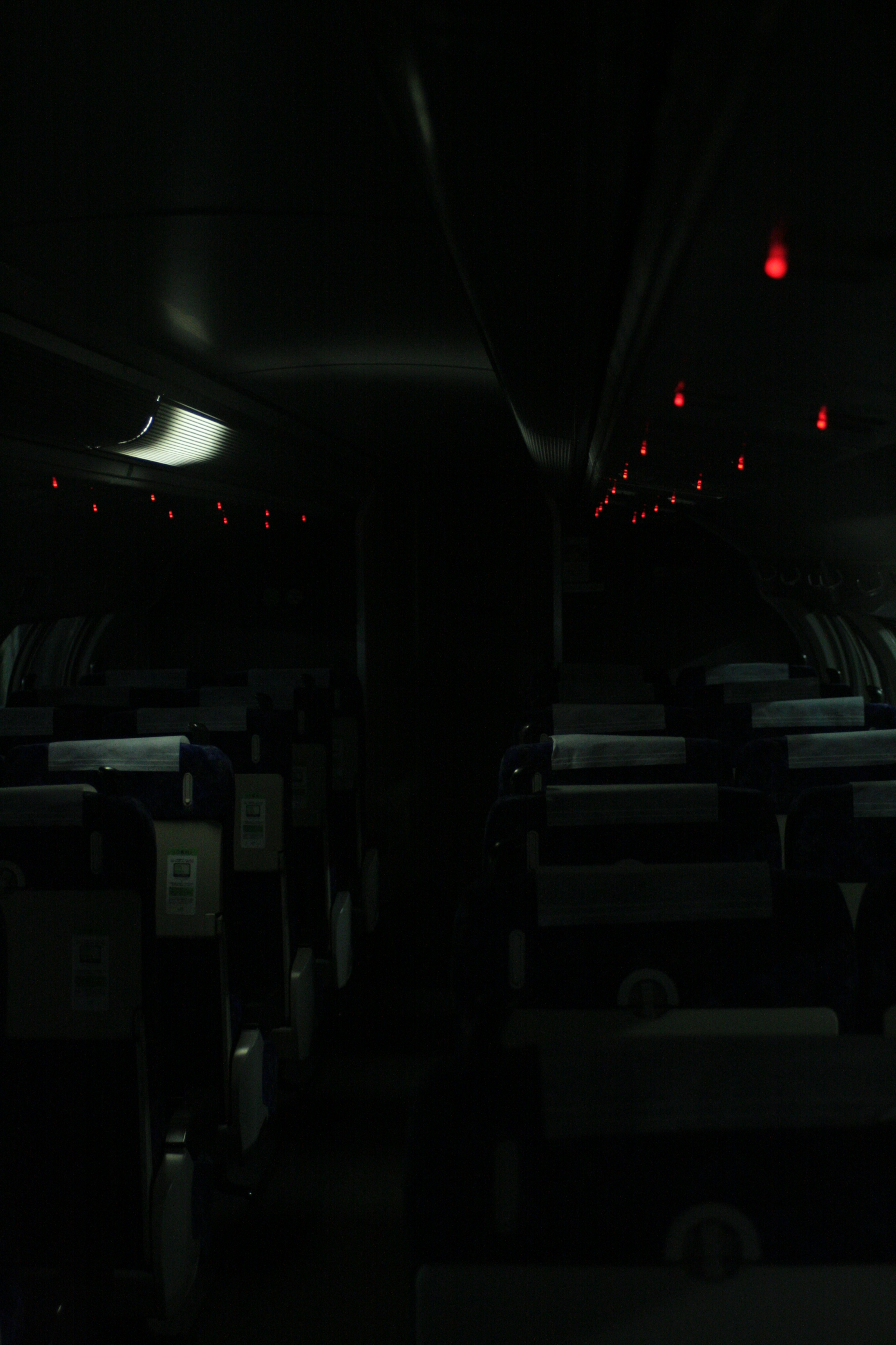 Interior oscuro de un avión con luces rojas iluminadas