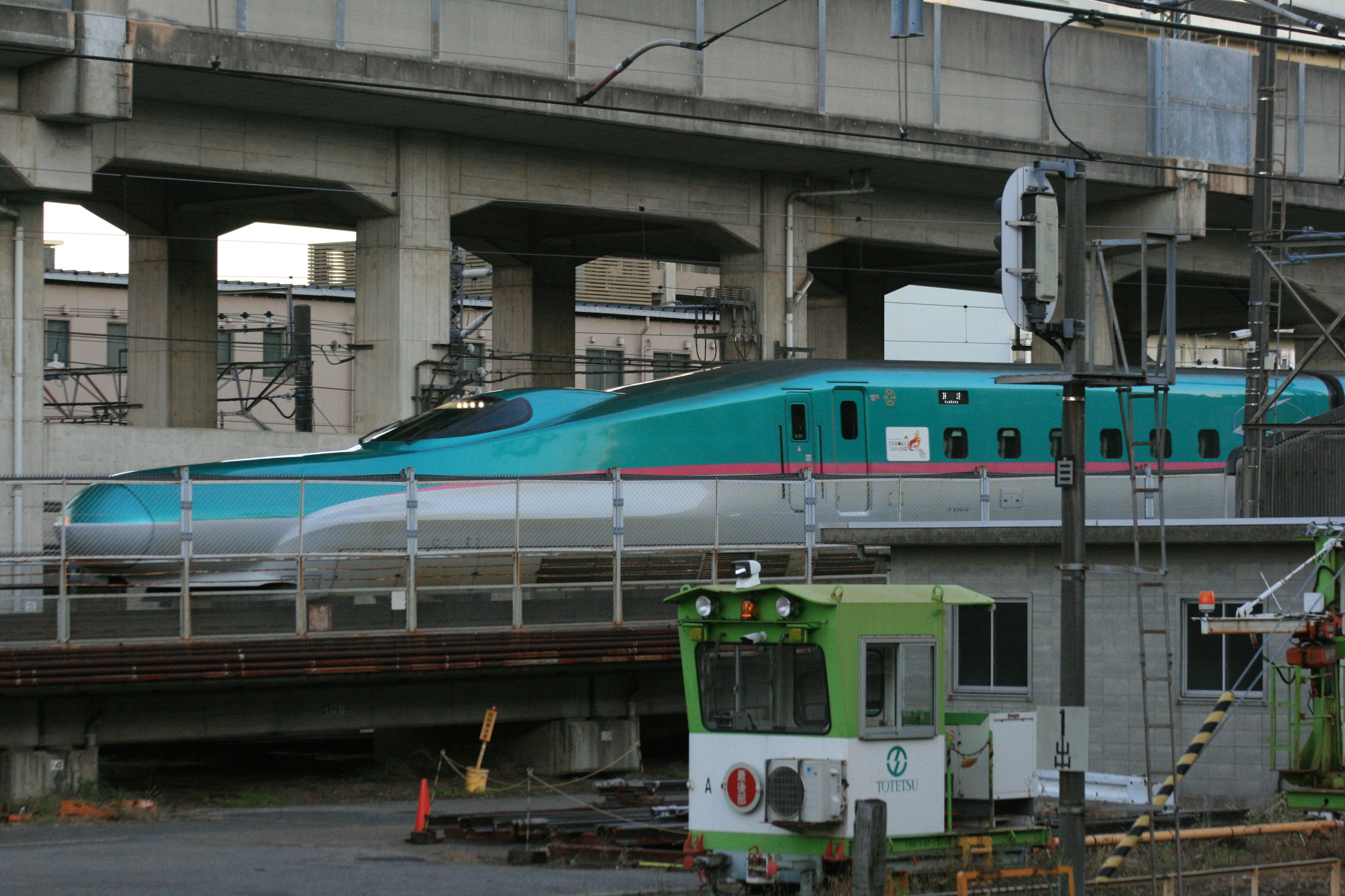 Tren Shinkansen en una estación con colores turquesa y blanco