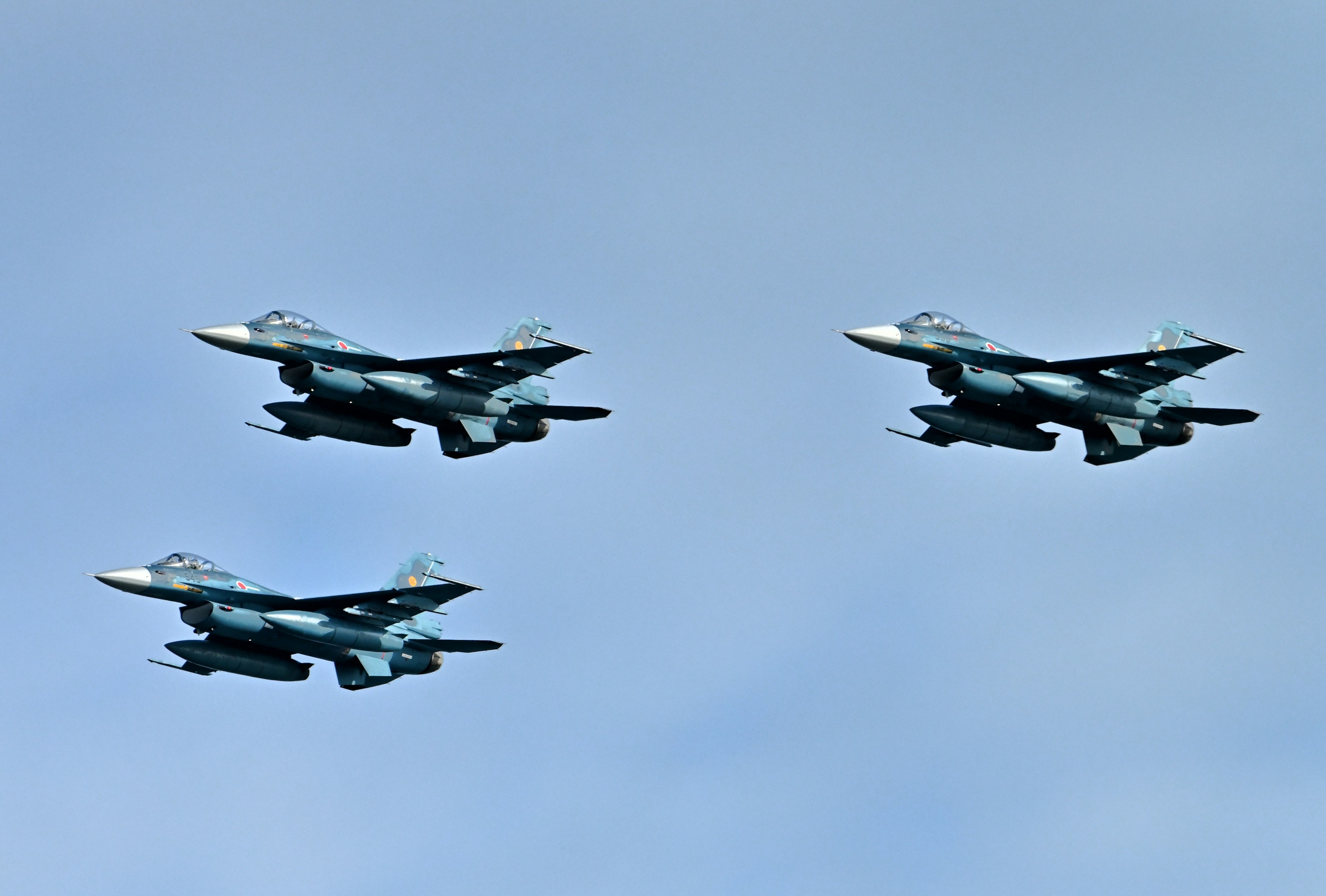 Drei Kampfflugzeuge fliegen in Formation vor einem blauen Himmel