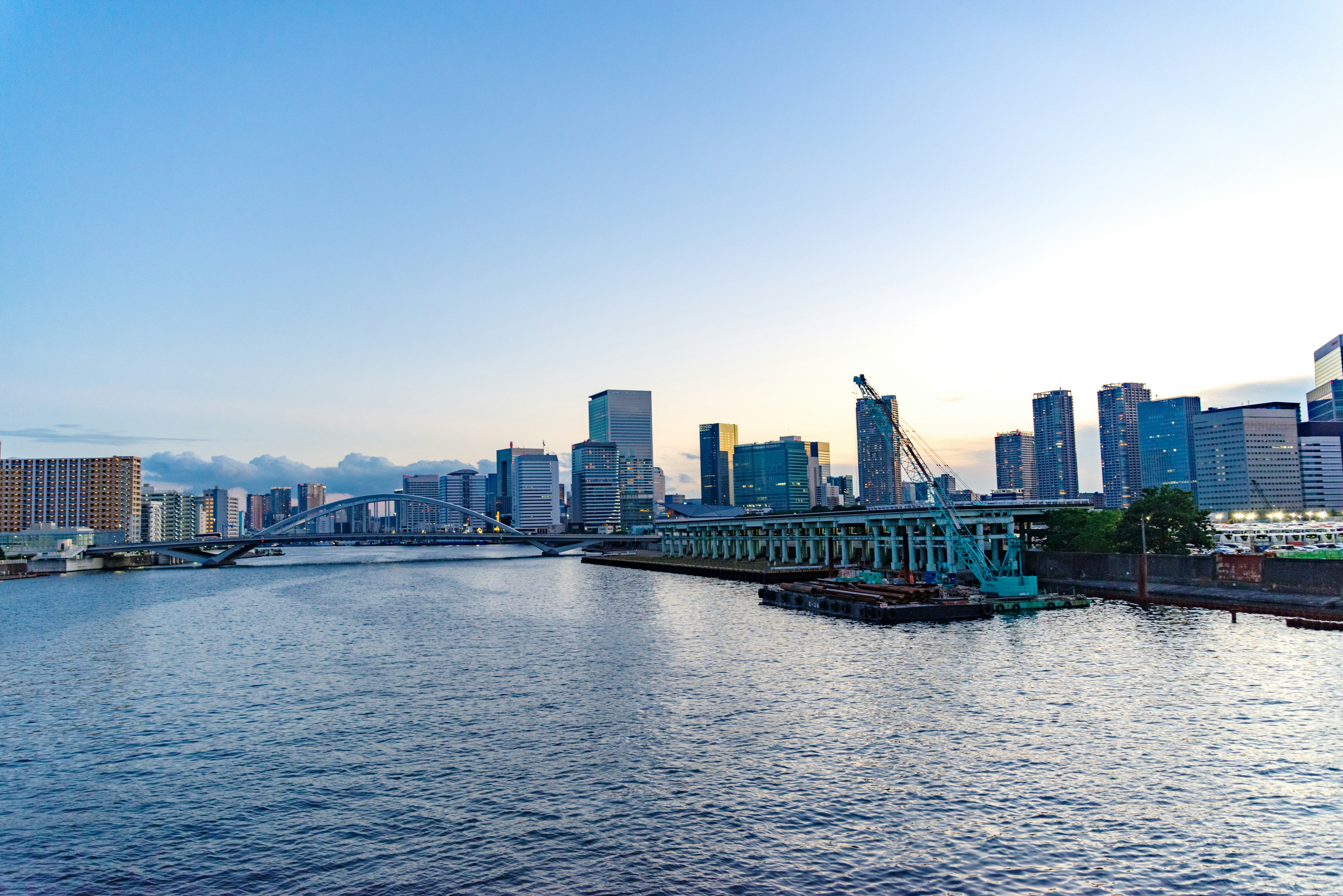 City skyline with a river reflecting the blue sky