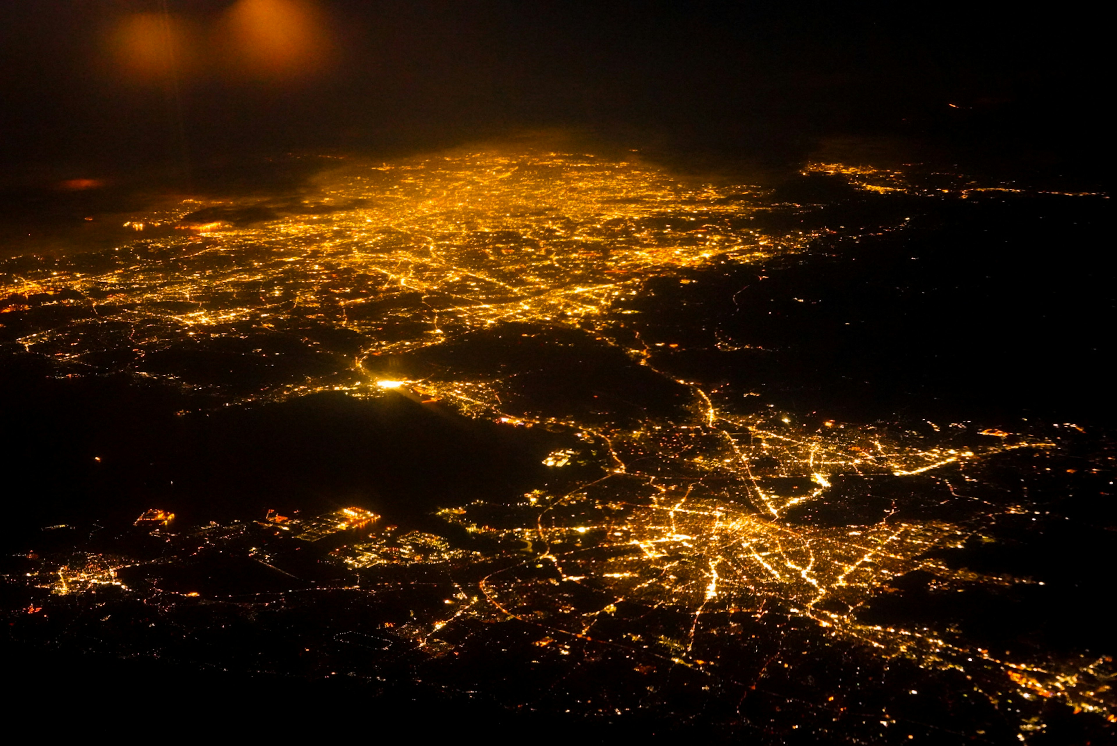 Vue aérienne d'une ville la nuit avec des motifs lumineux brillants et des contours clairs des routes et des bâtiments