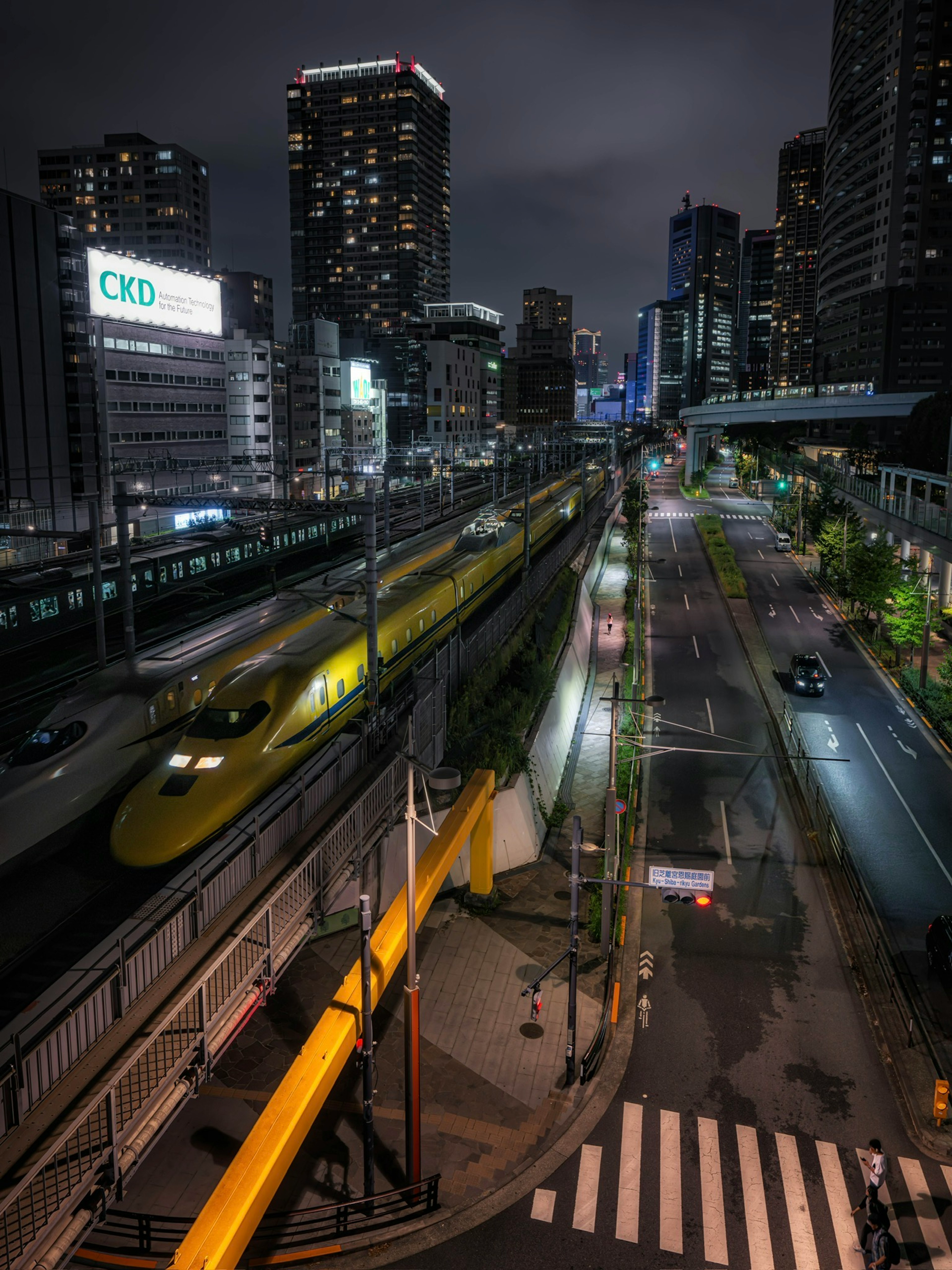 Night cityscape featuring a Shinkansen train and skyscrapers