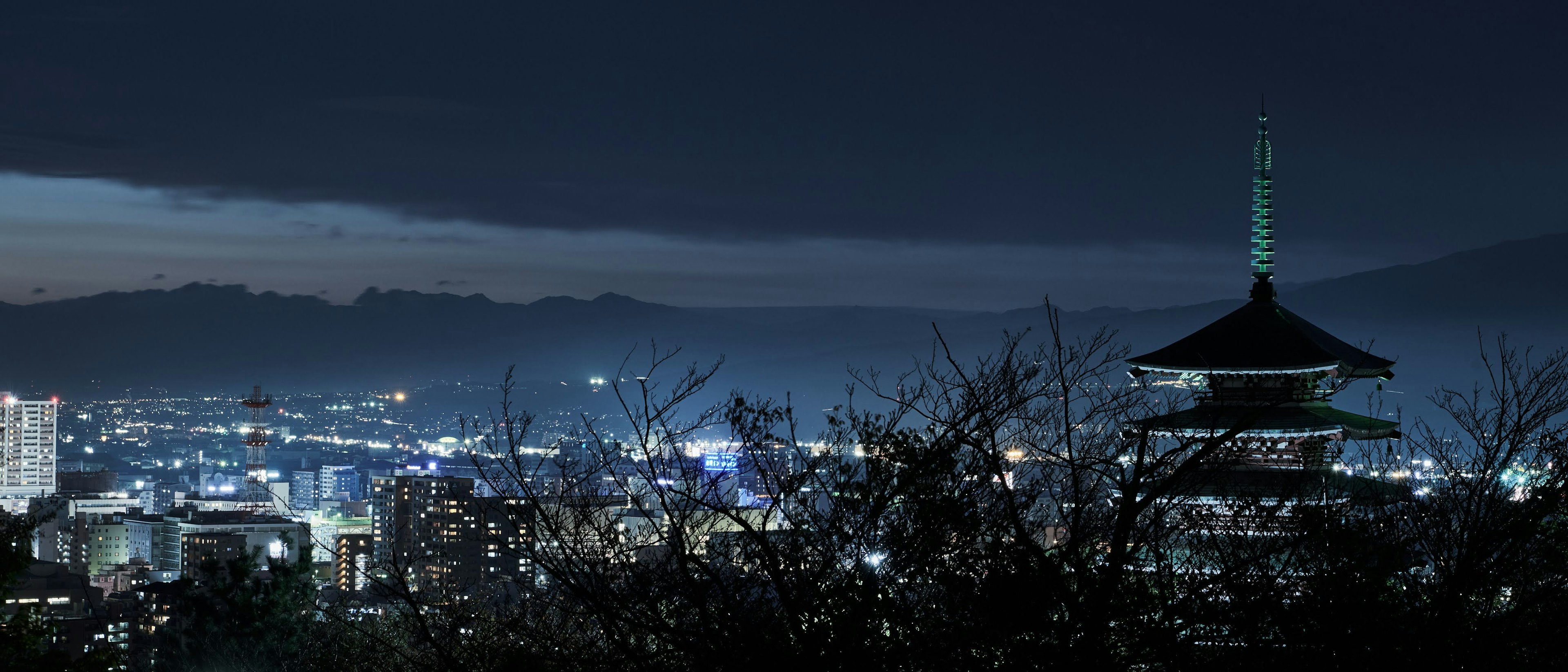 夜景の中に浮かぶ伝統的な塔と都市の光