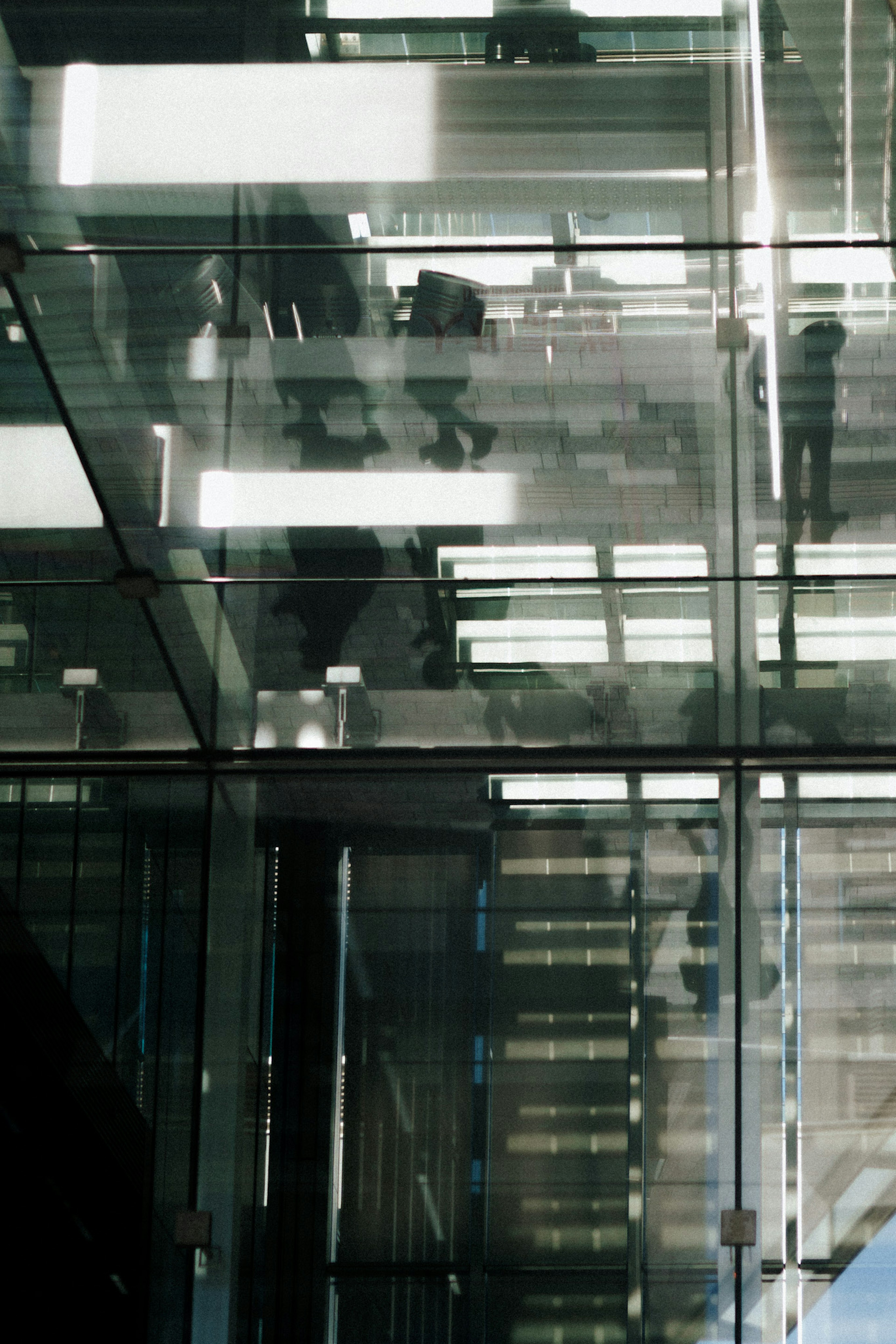 Glass staircase with silhouettes of people reflected