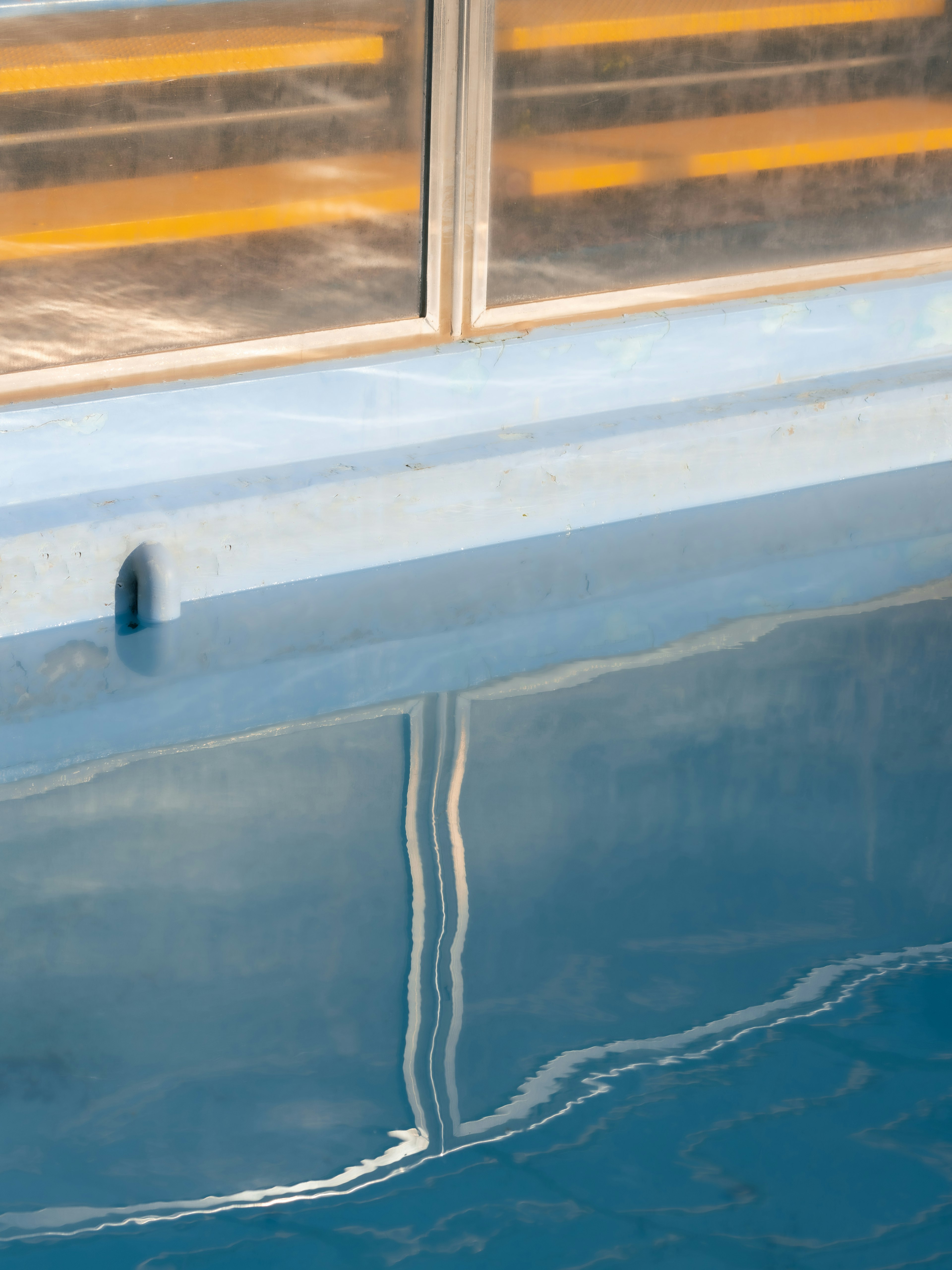 Reflet de la lumière et des ombres sur l'eau bleue de la piscine