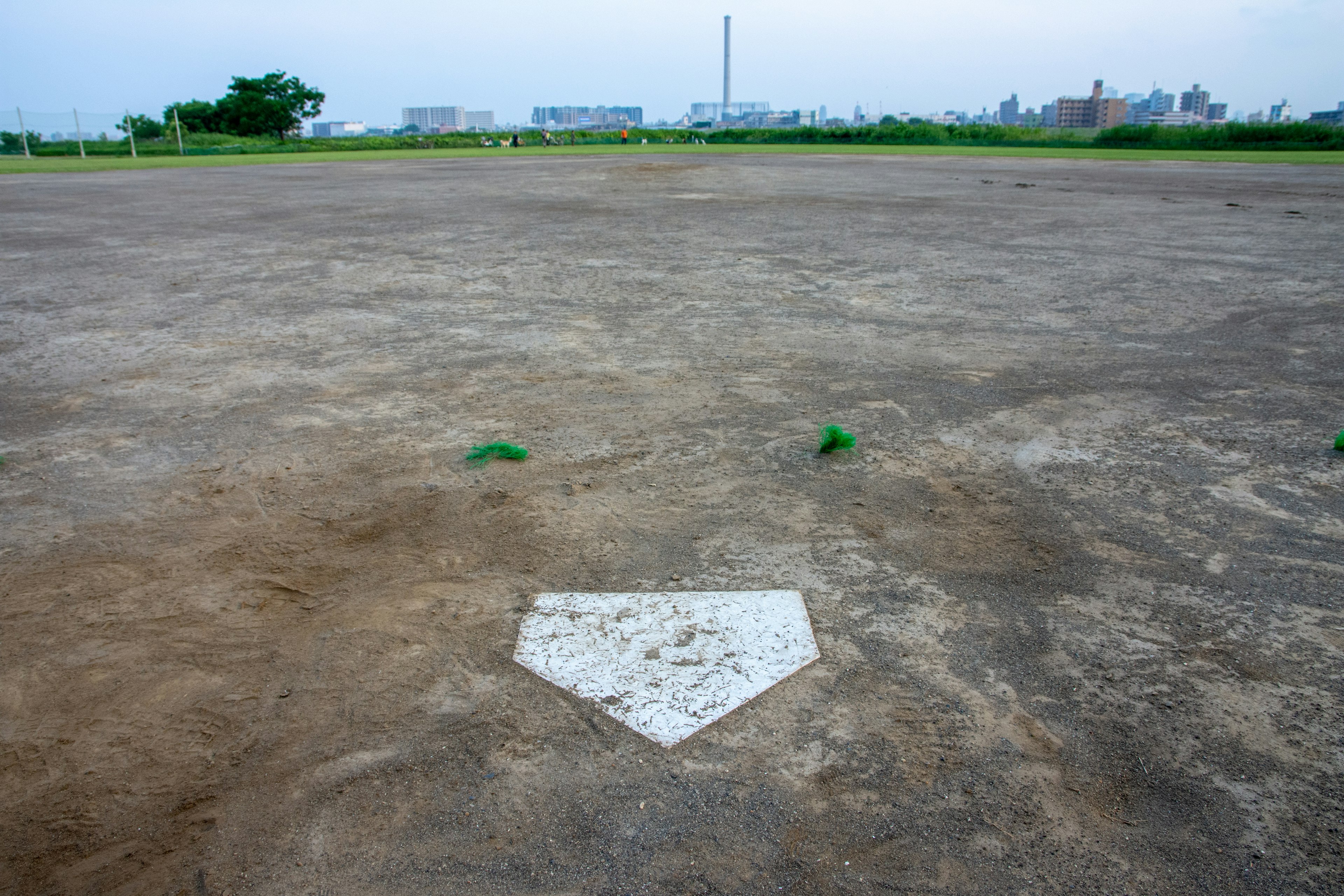 Empty baseball field featuring home plate and surrounding grass