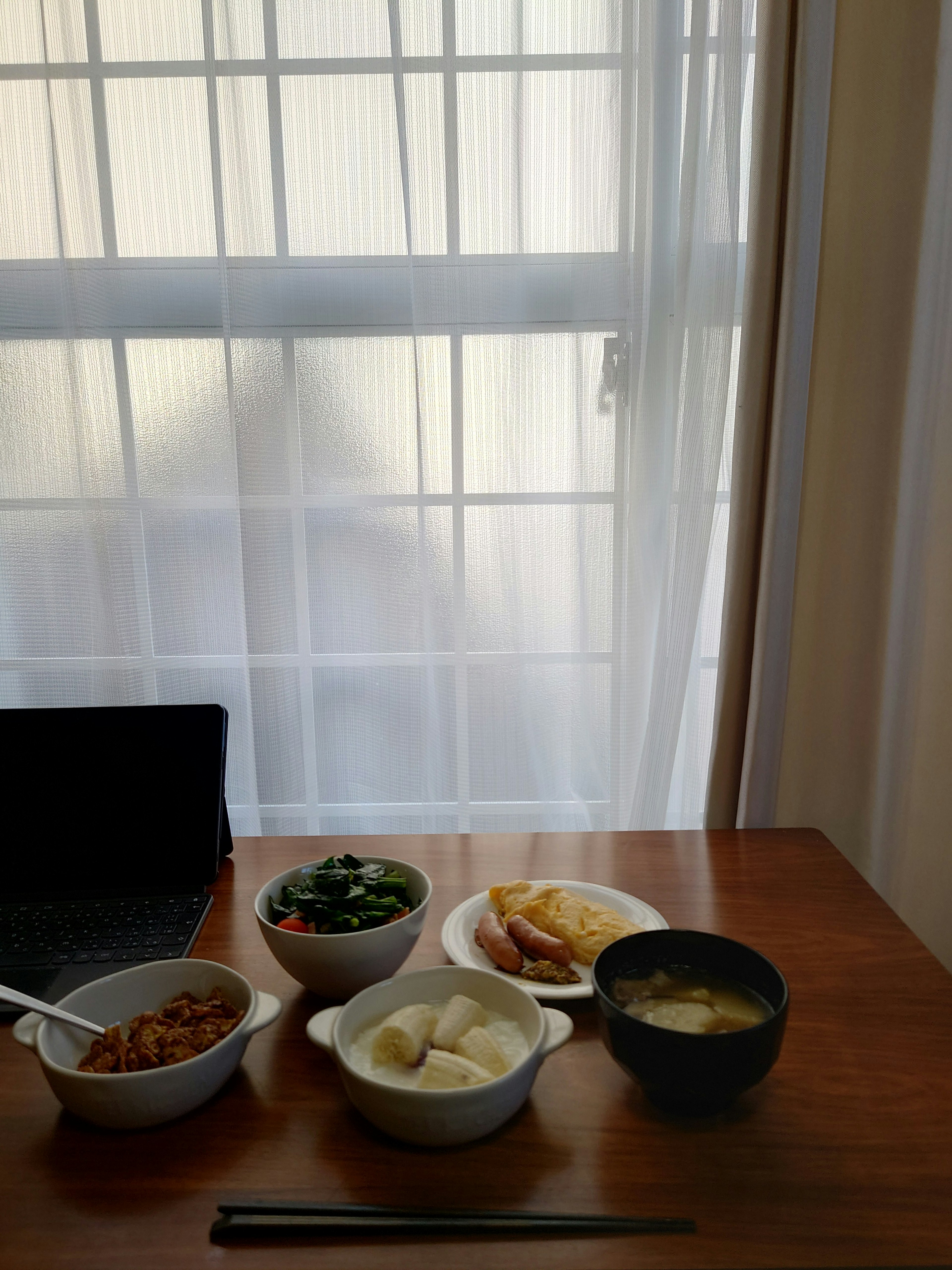 A traditional Japanese breakfast set on a wooden table near a window