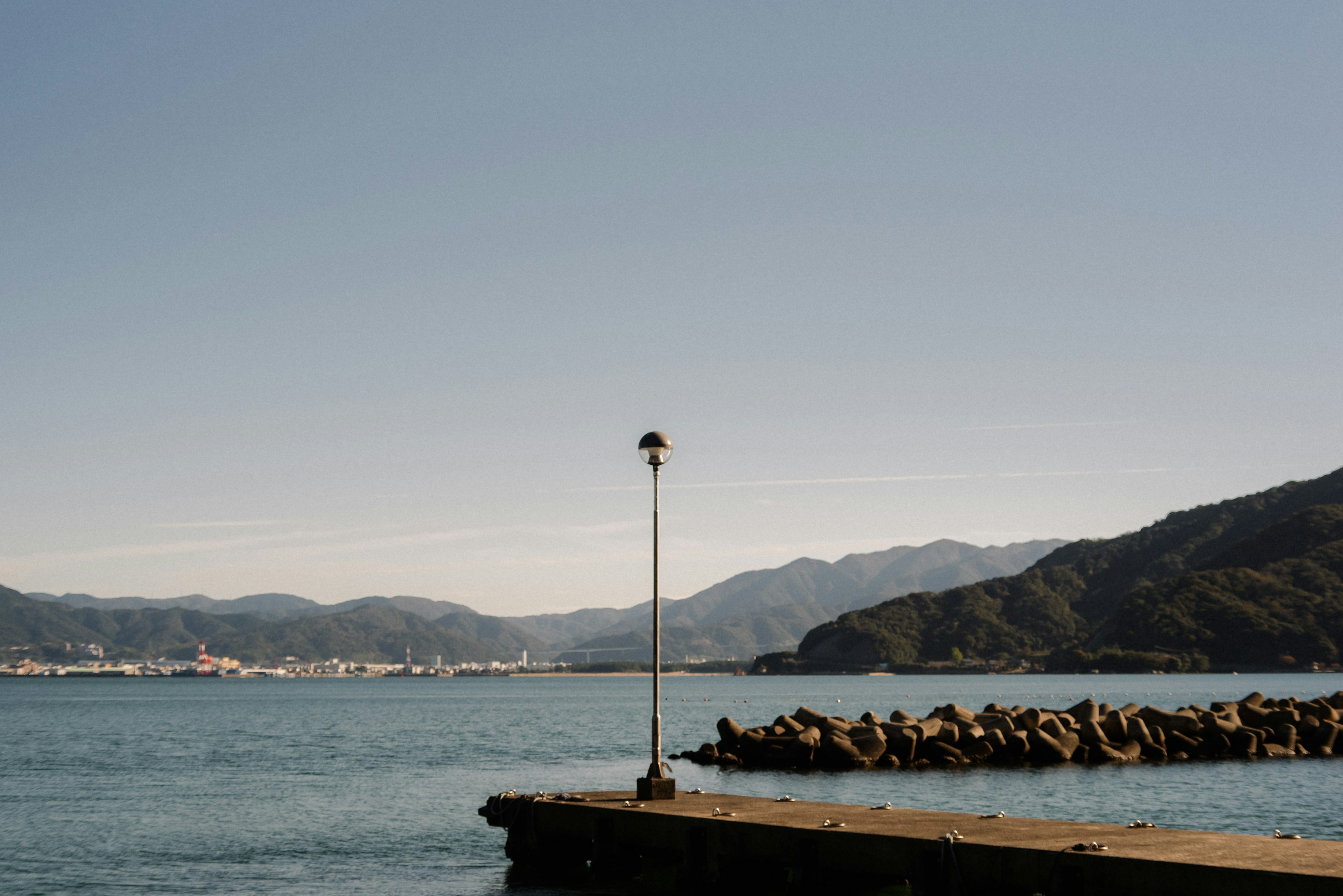 A beautiful view of the sea and mountains with a lighthouse