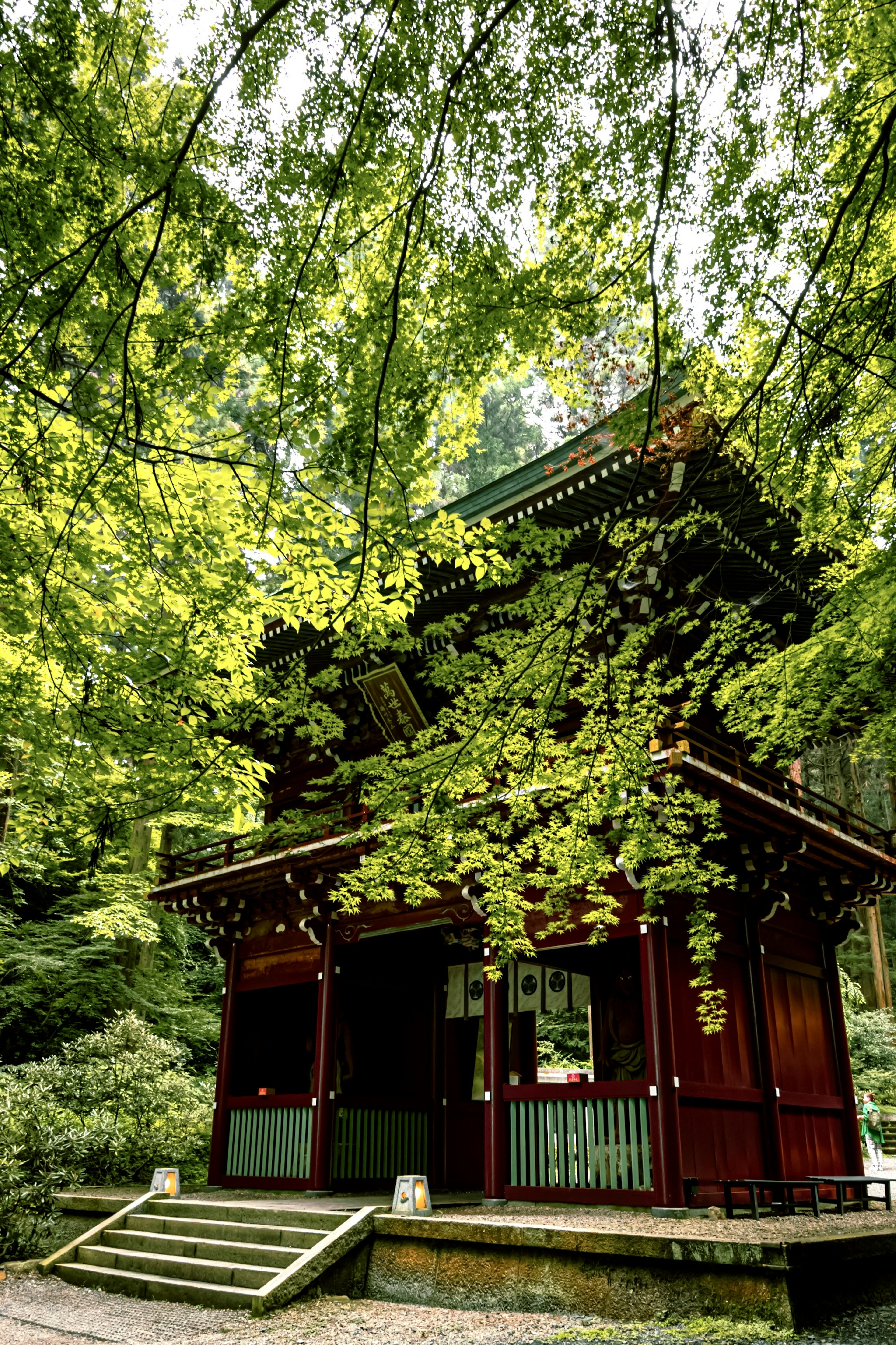 Traditional red building surrounded by lush green trees