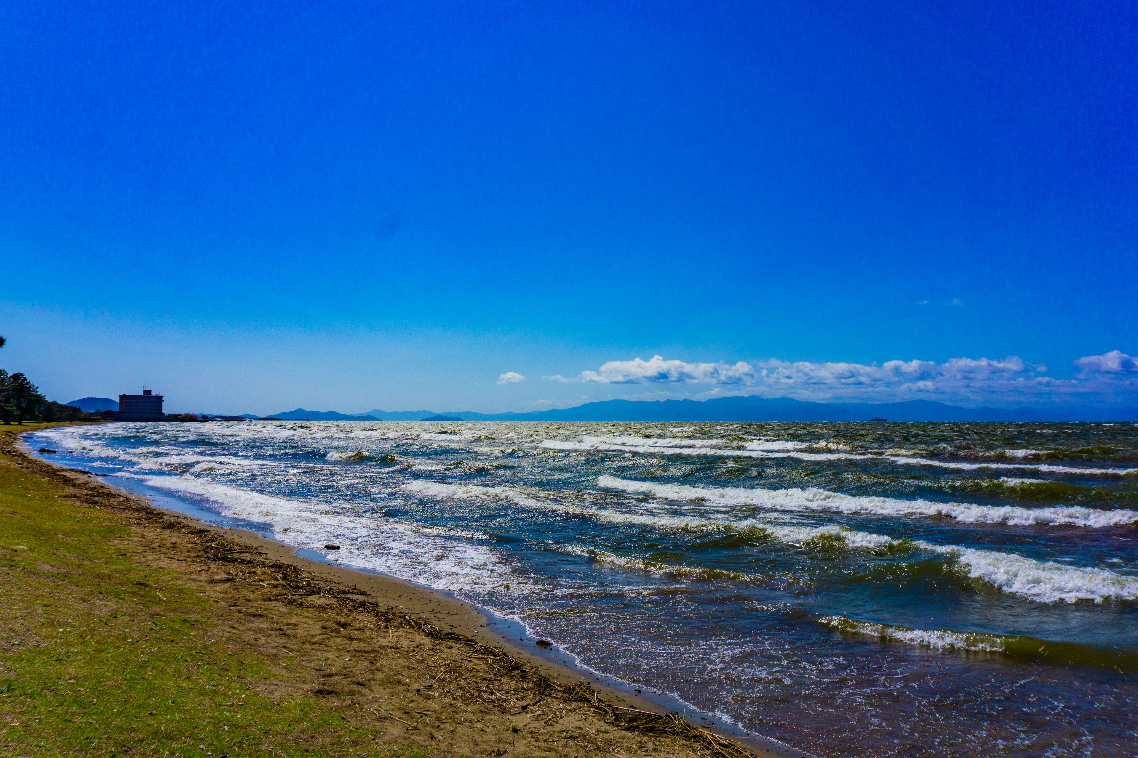 青い空と波が広がる湖の風景