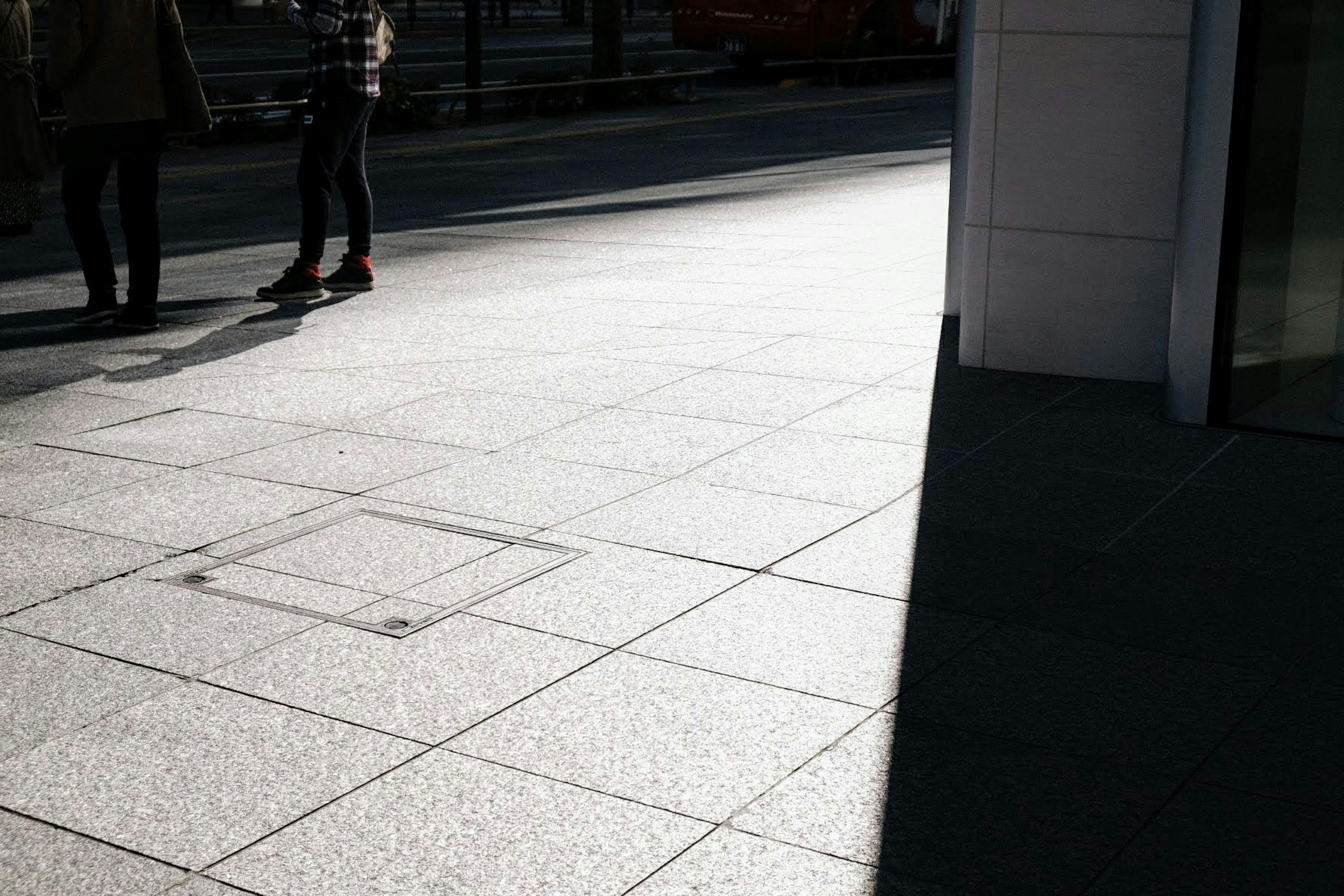 人々が歩いている明るい街の歩道の一部