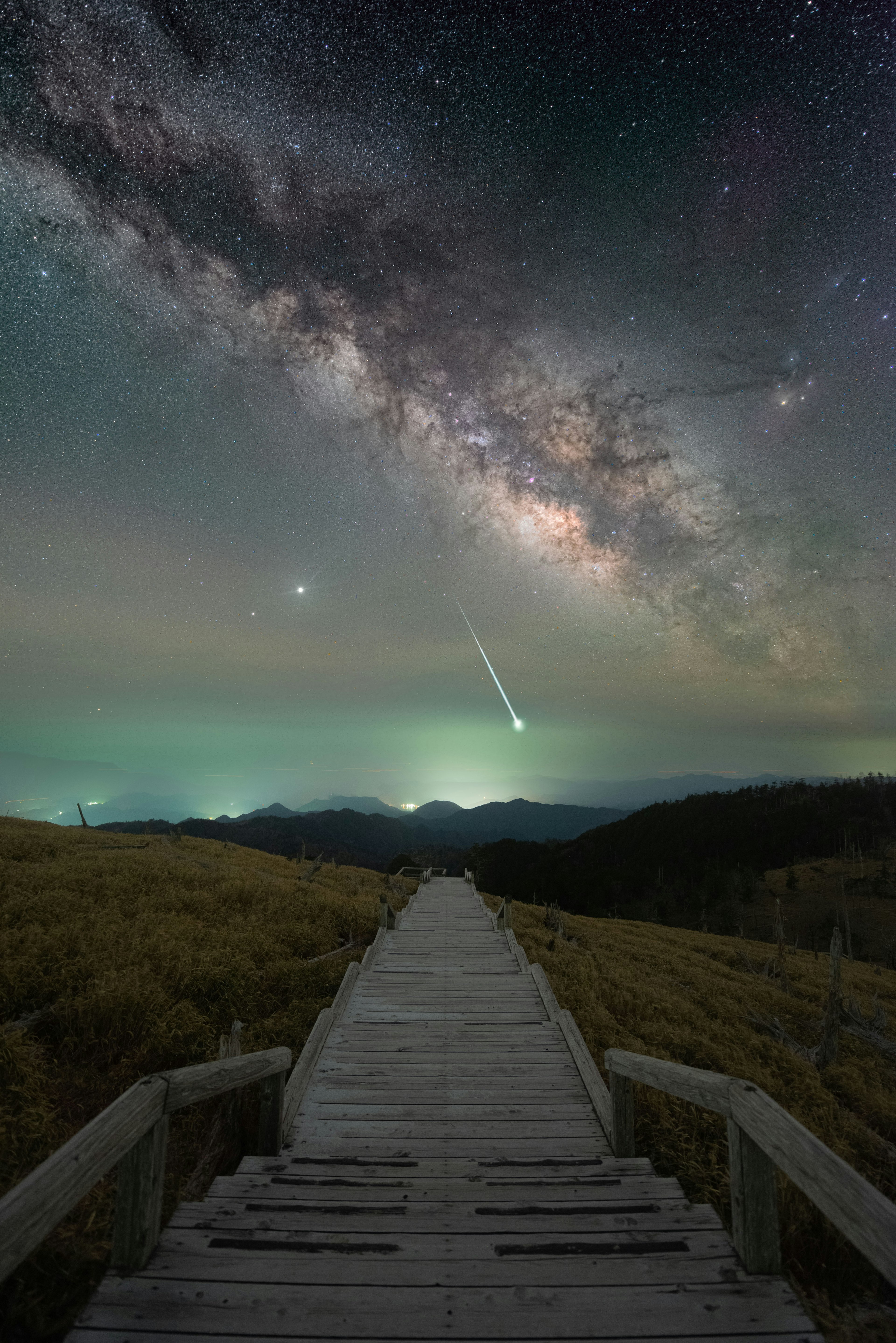 Wooden pathway under a starry sky with a stunning view of the Milky Way