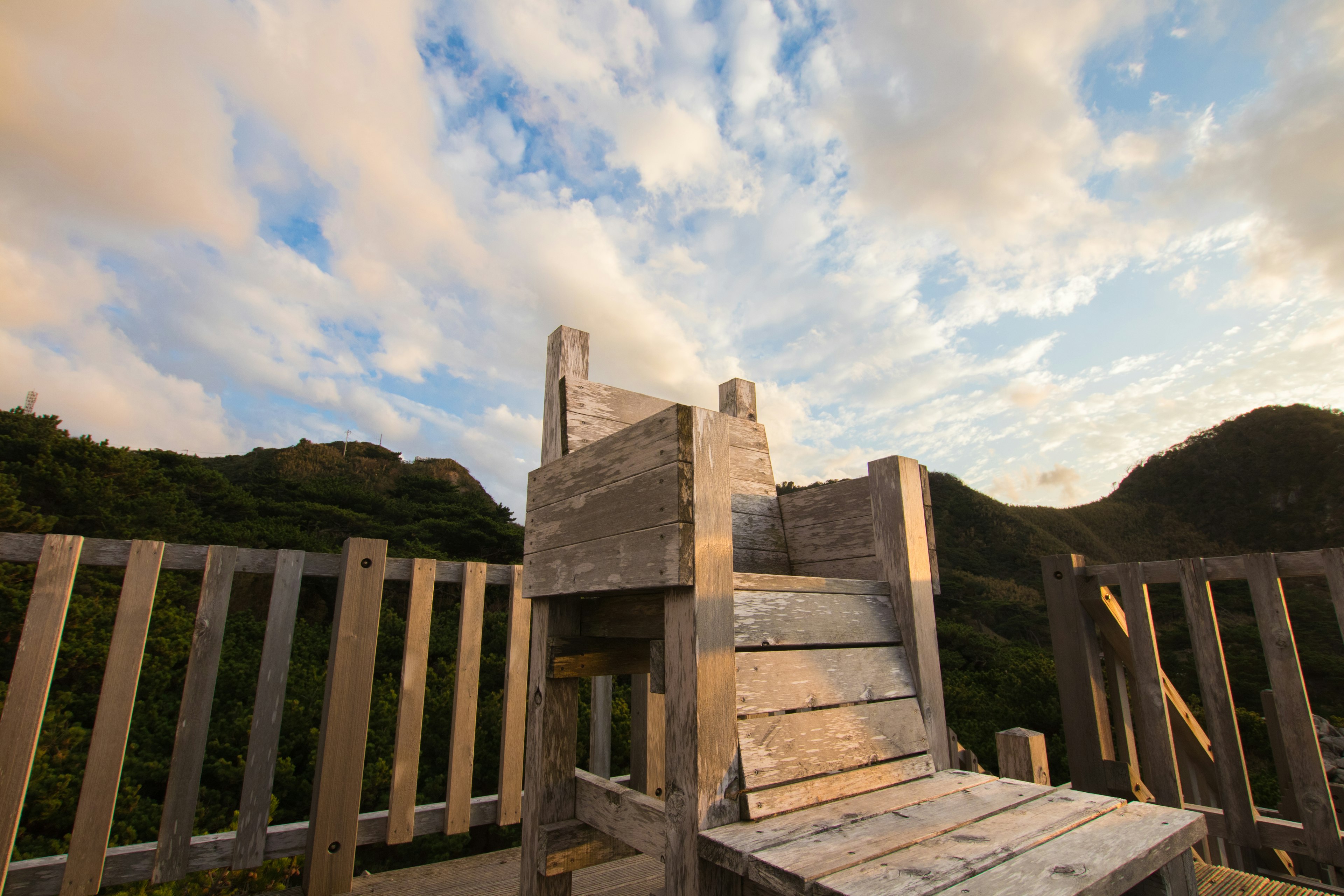 Estructura de juego de madera con vista al cielo azul y nubes