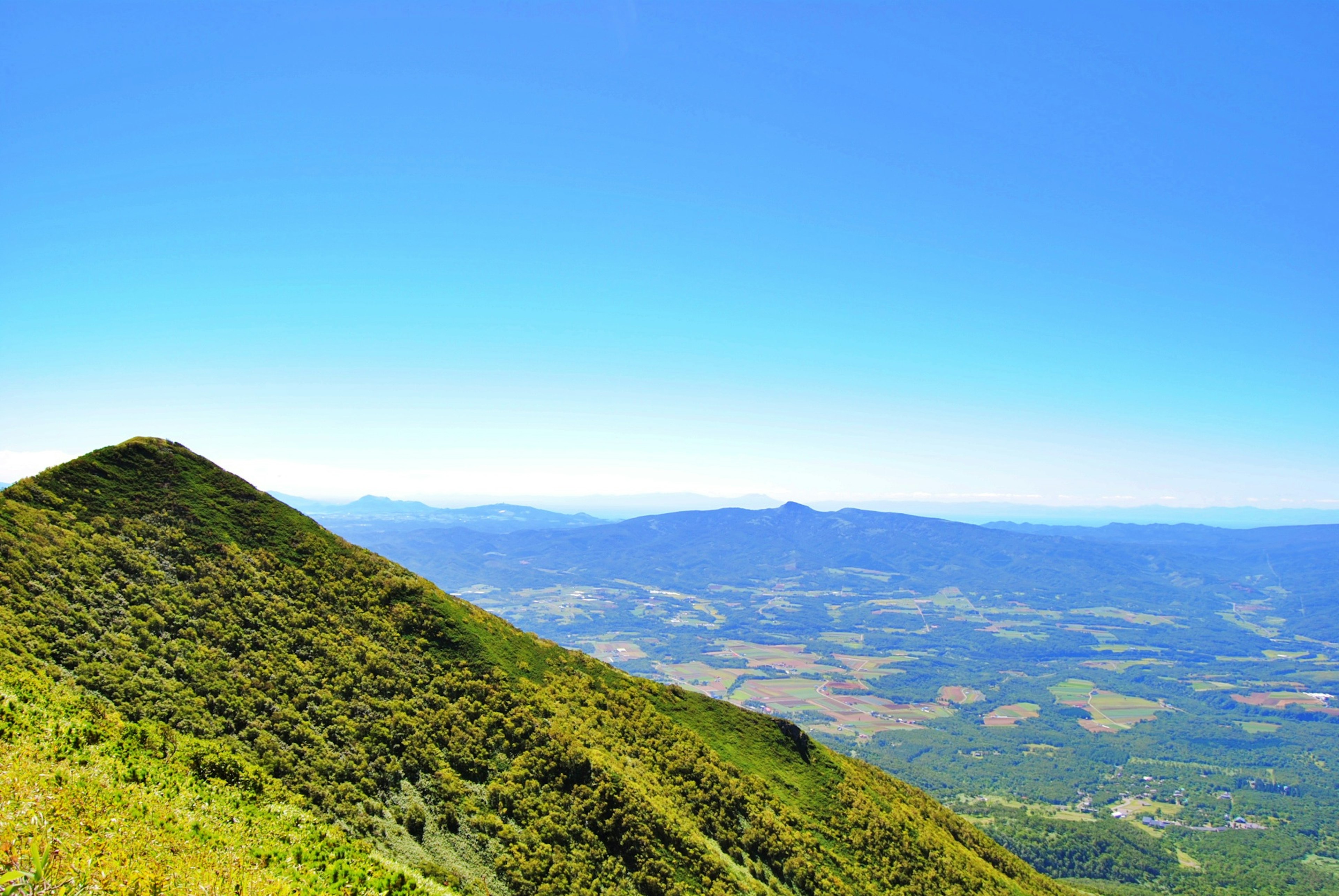 Eine malerische Aussicht auf grüne Hügel unter einem blauen Himmel