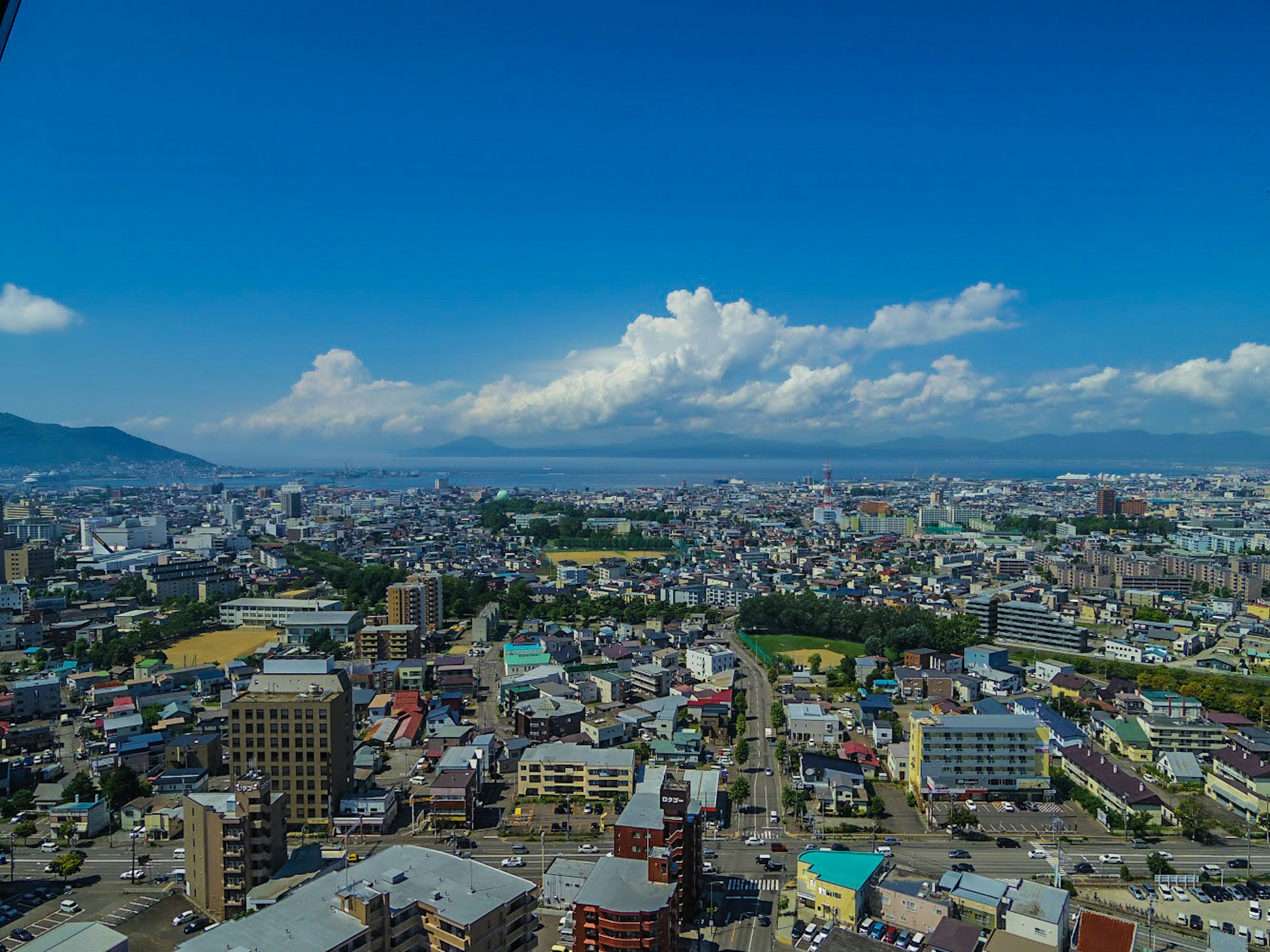 ทิวทัศน์เมืองแบบพาโนรามาใต้ท้องฟ้าสีฟ้าสดใสพร้อมเมฆ