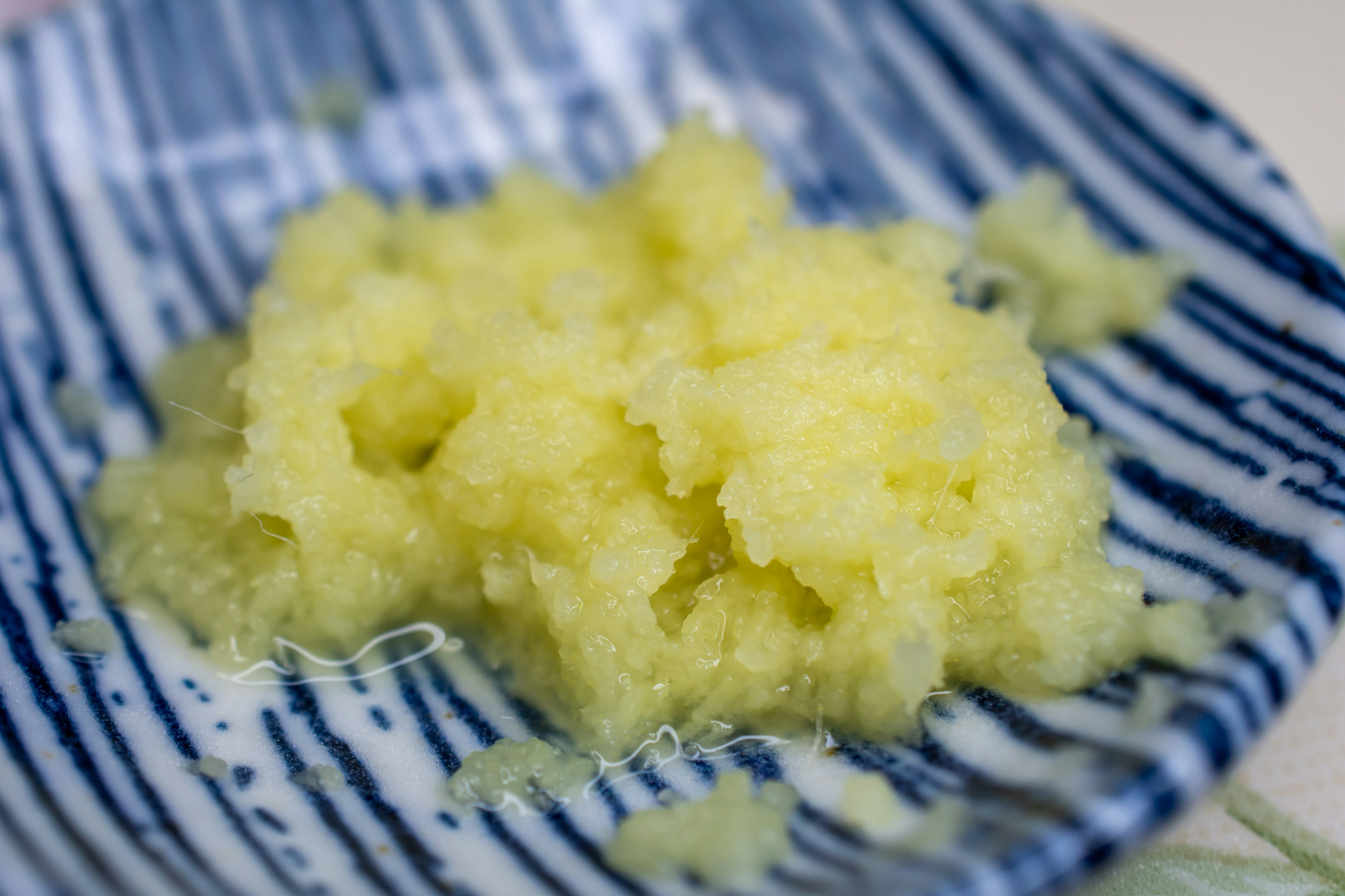 Freshly grated ginger on a blue striped plate