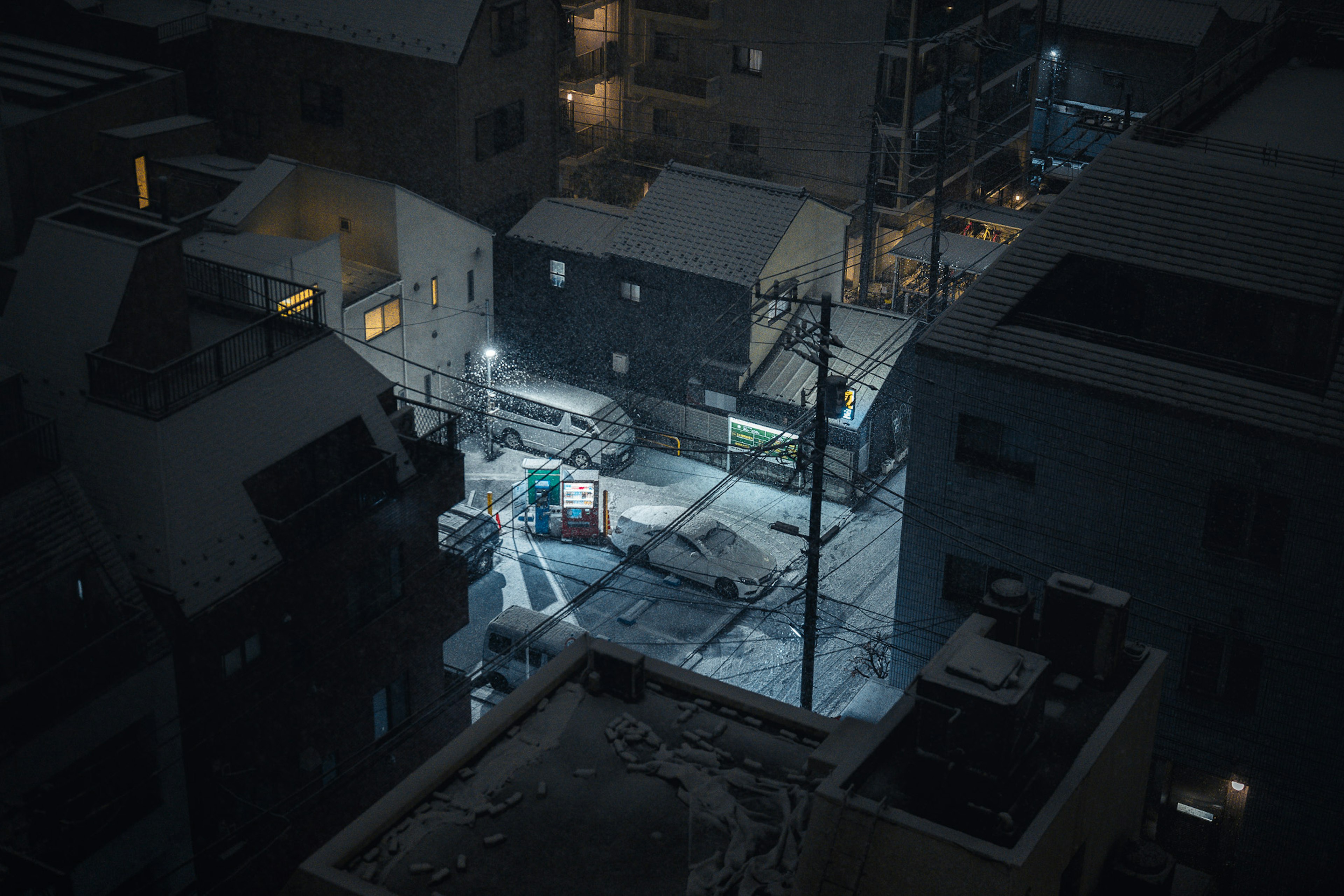 雪に覆われた都市の夜景で静かな通りと車両が見える