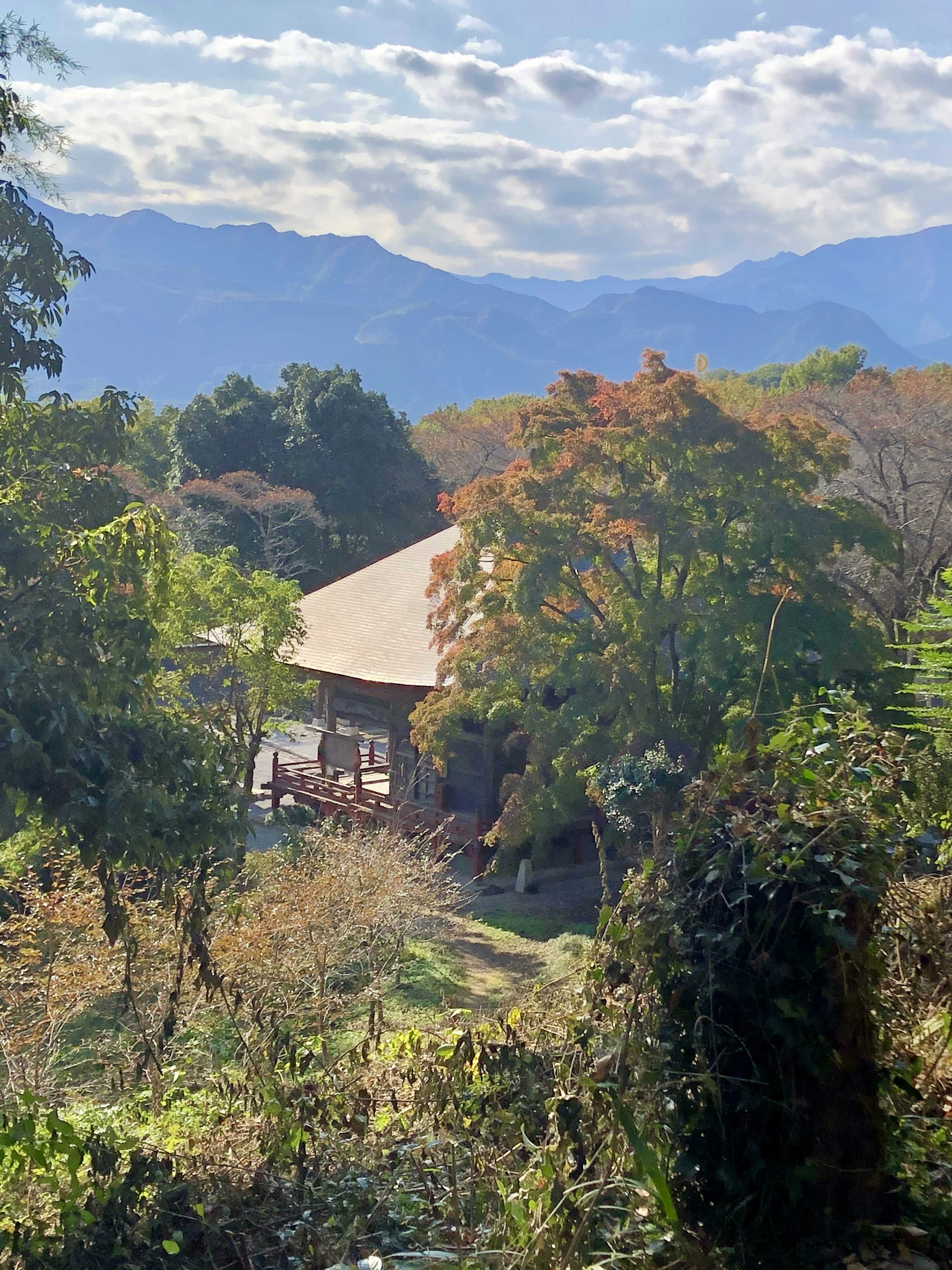 山々に囲まれた静かな農村の風景にある伝統的な日本家屋