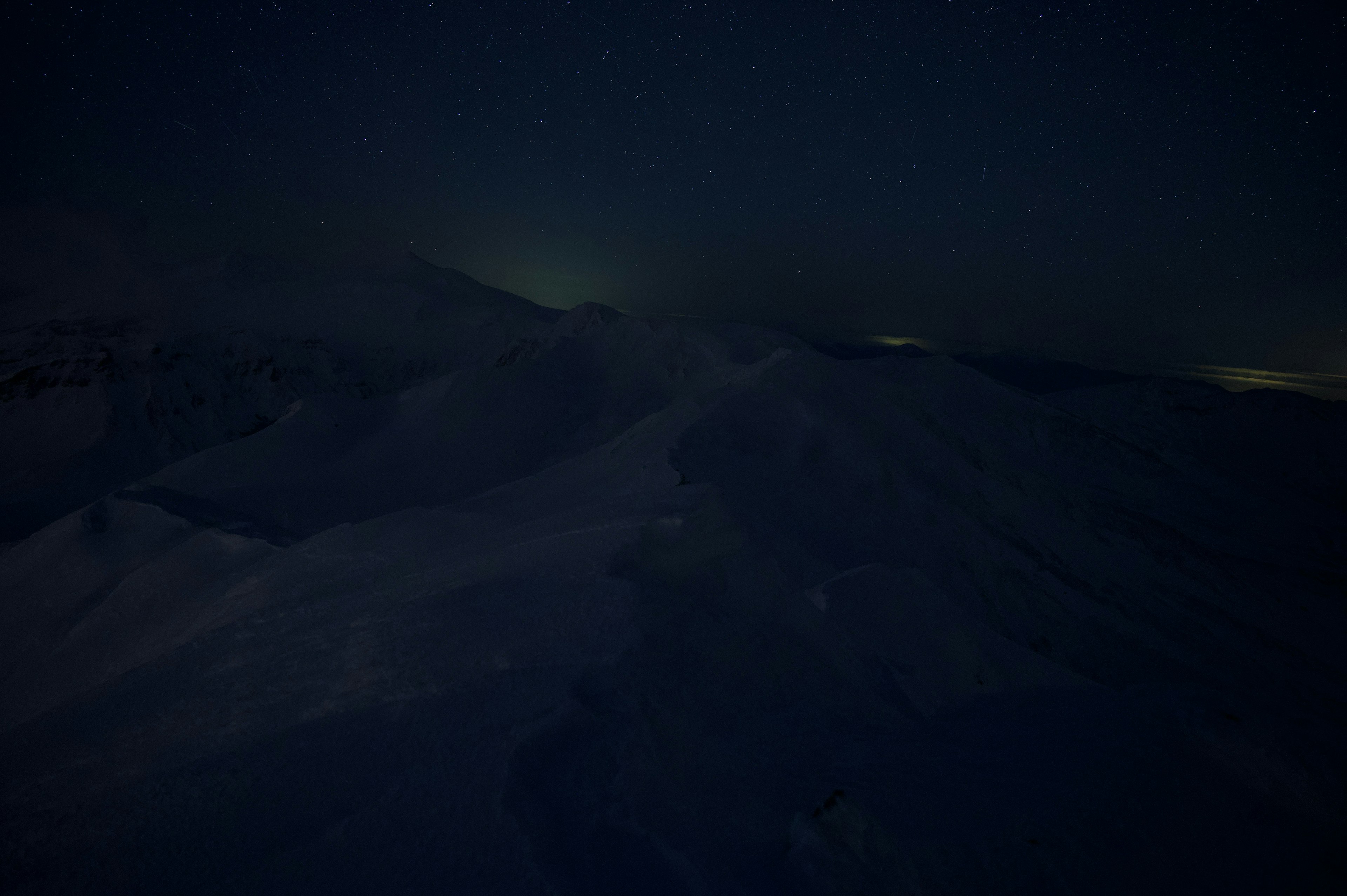 Snow-covered mountains under a starry night sky