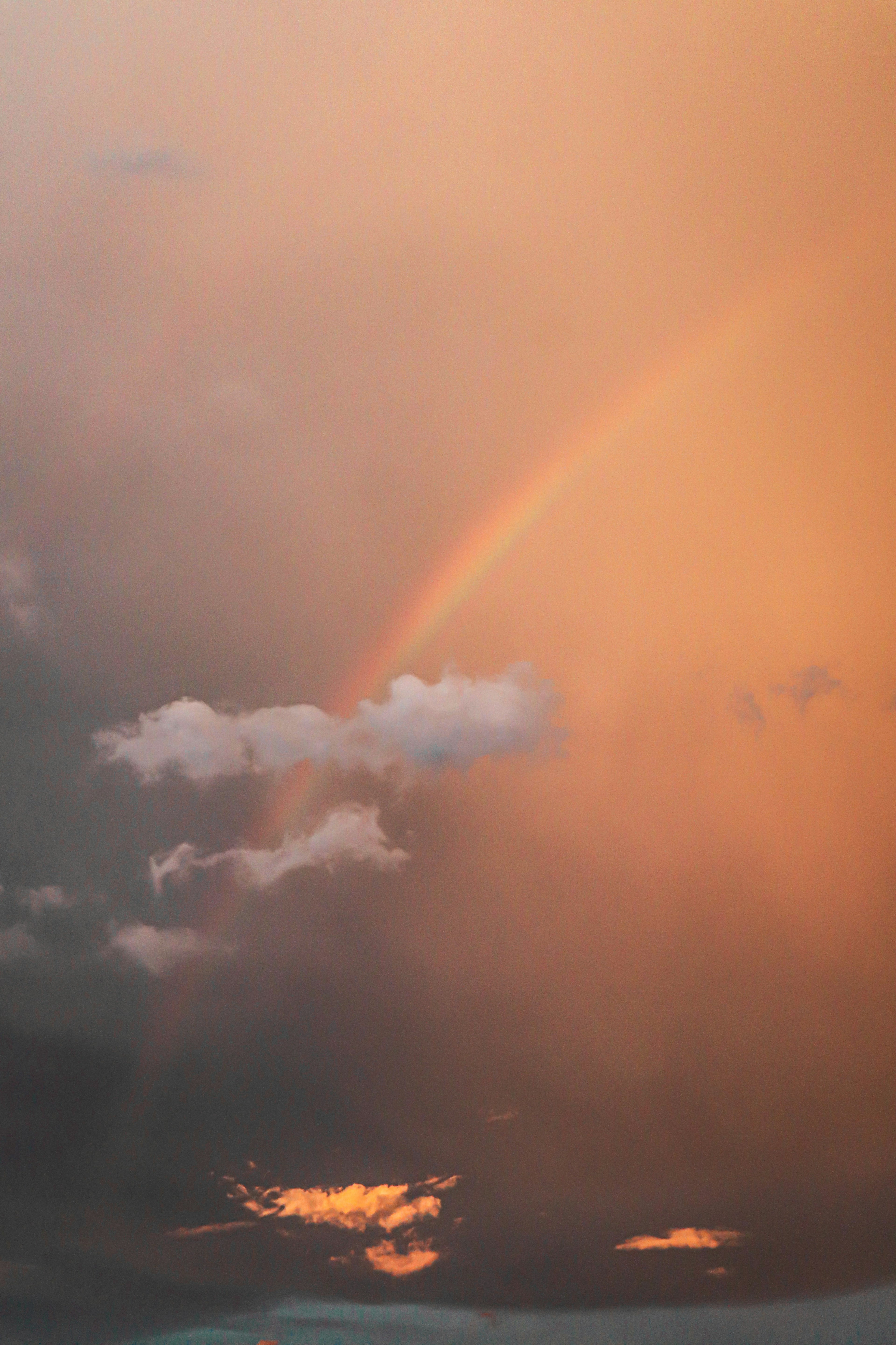 Une belle scène d'un arc-en-ciel et de nuages dans un ciel de coucher de soleil