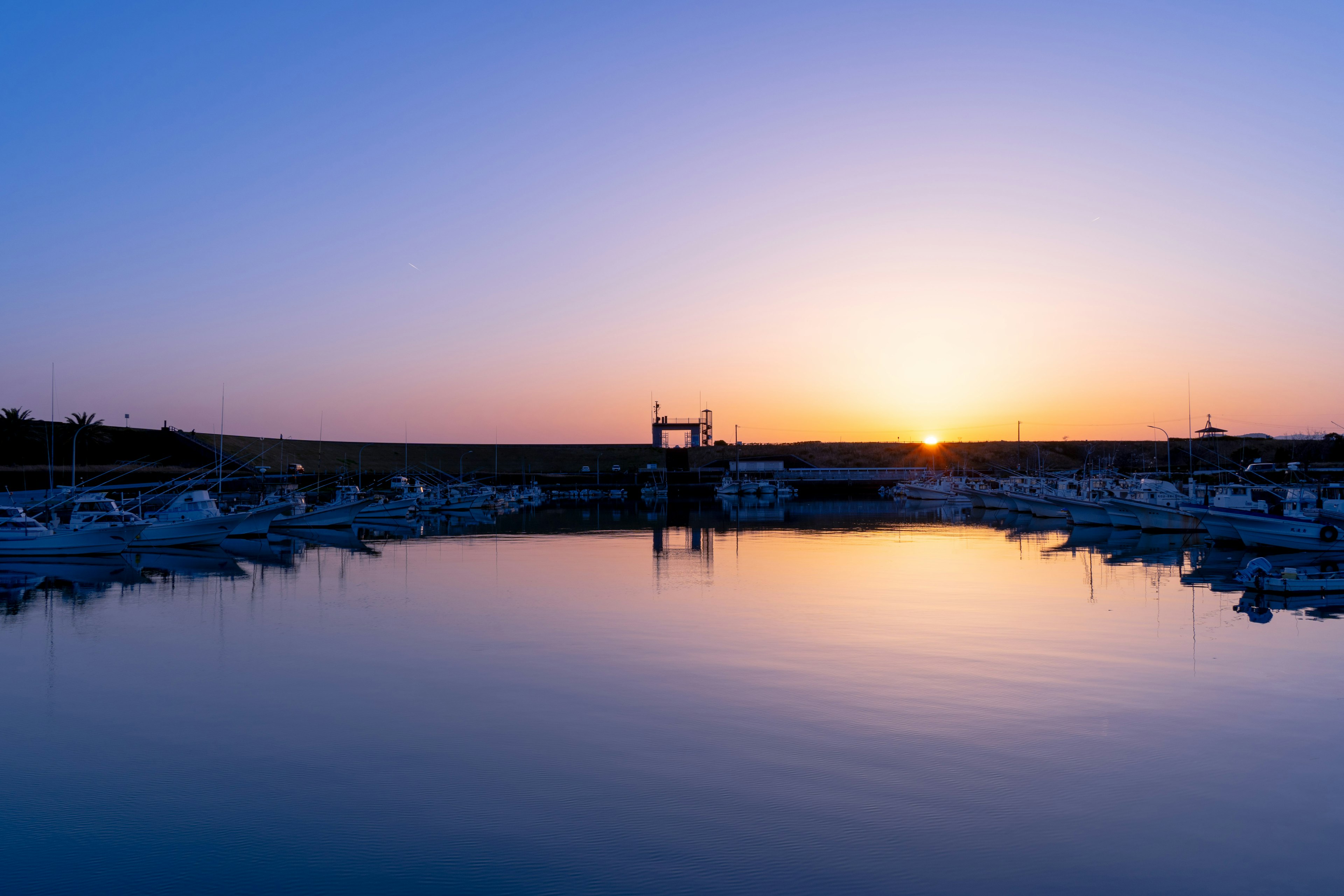 Puerto sereno con botes y una hermosa puesta de sol