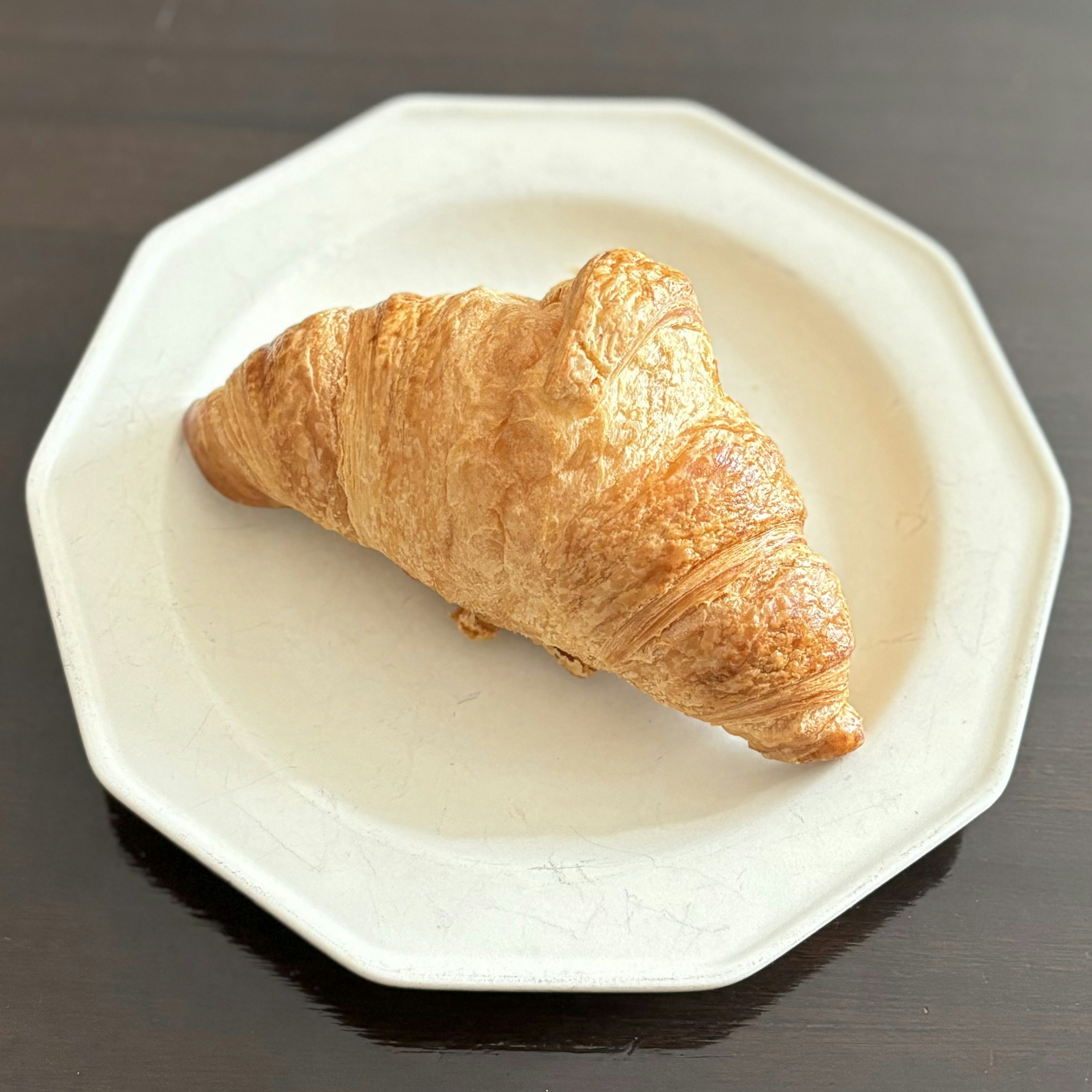 Croissant emas di atas piring putih