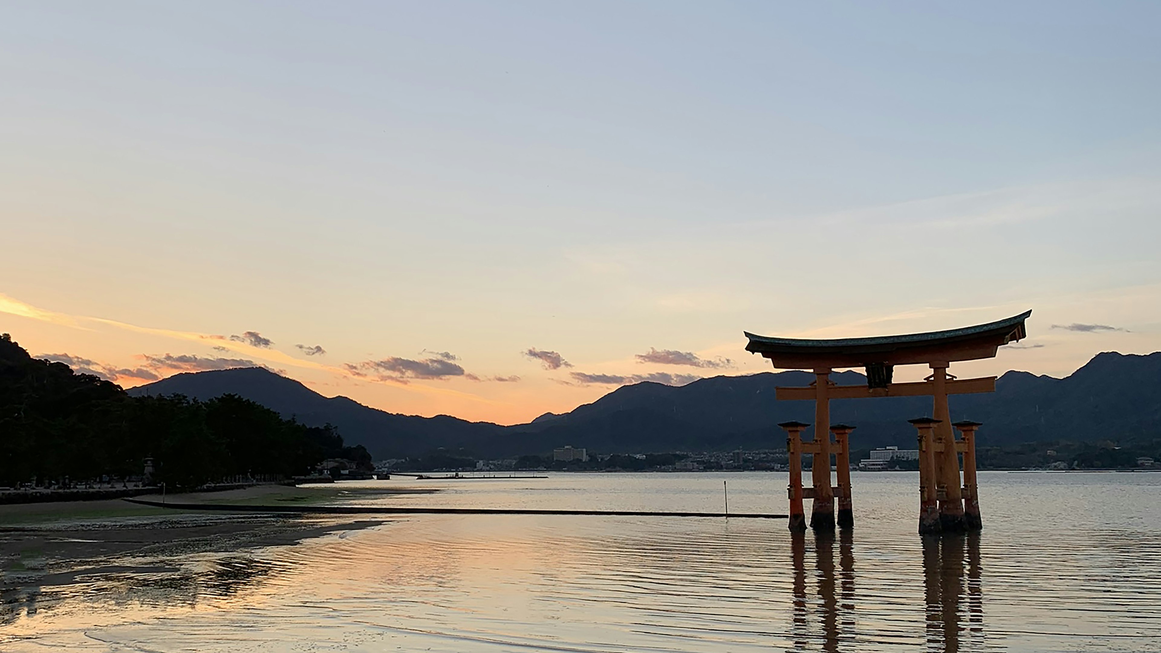 在美麗的夕陽中矗立的鳥居和寧靜的水面