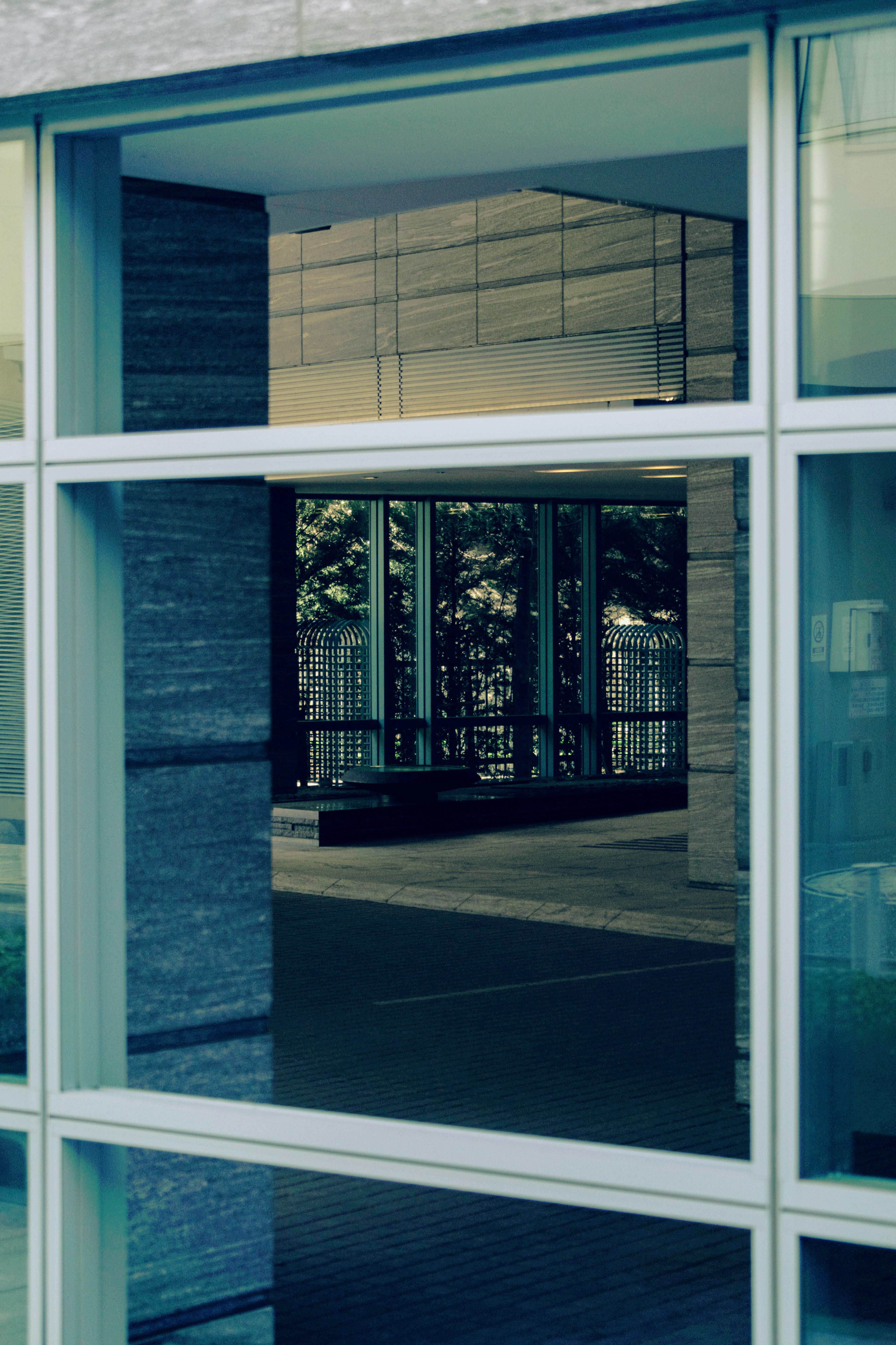 Reflejo y vista interior a través de una ventana de edificio moderno