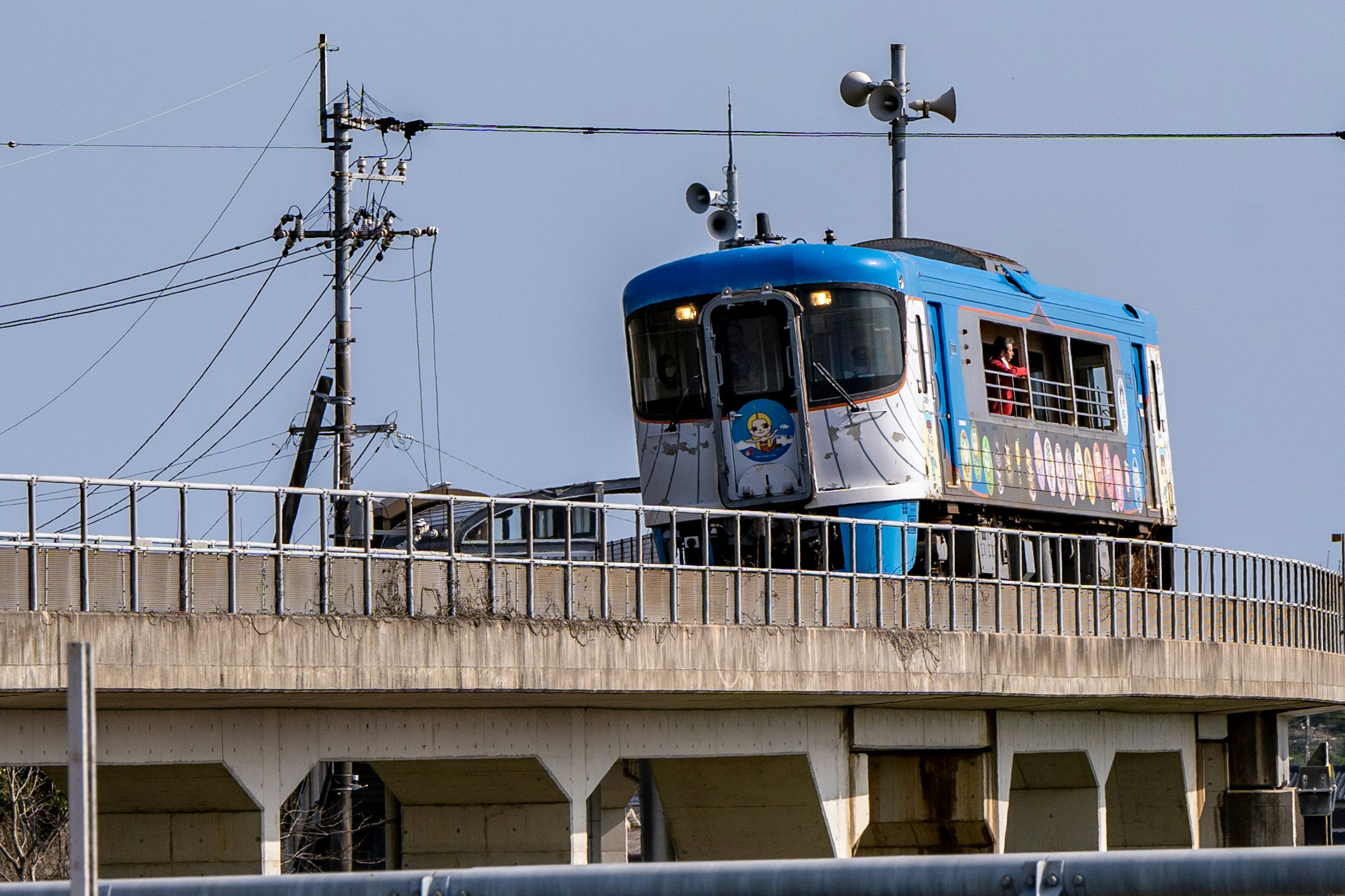 Train bleu circulant sur une voie surélevée