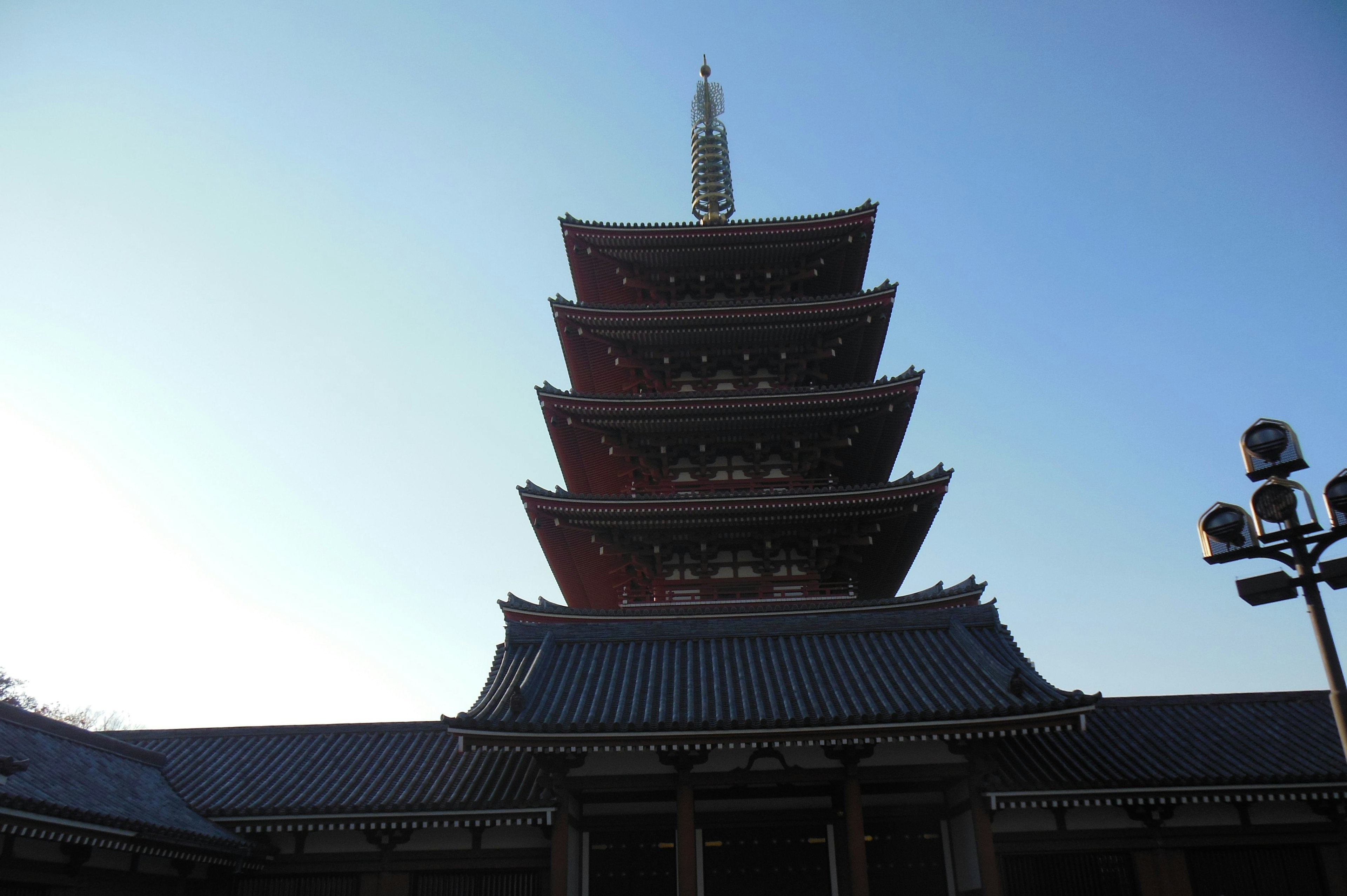 Vista di una pagoda a cinque piani sotto un cielo blu chiaro che mostra l'architettura giapponese tradizionale